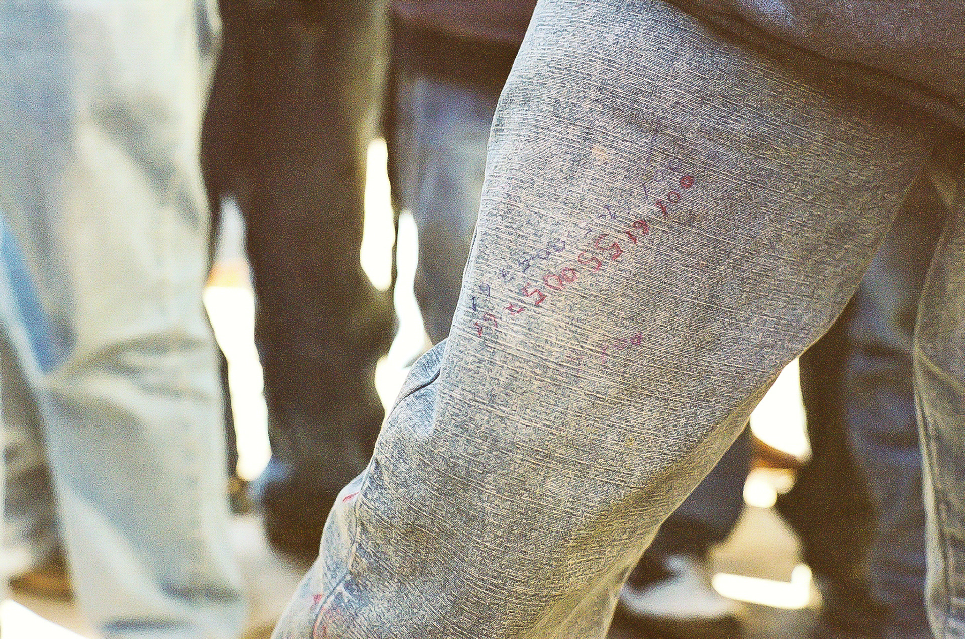 Scrawling on the pants leg of Michalandro, a migrating teen from Chiapas, Mexico. They are phone numbers for his sister who lives "near Canada." His reasoning for writing them on his pants was - "if anything bad happens to me, if I die, at least they can tell my sister." In actuality, the area code is near Nashville, TN. I called the number a few months after this picture was taken. Michalandro had not yet arrived.