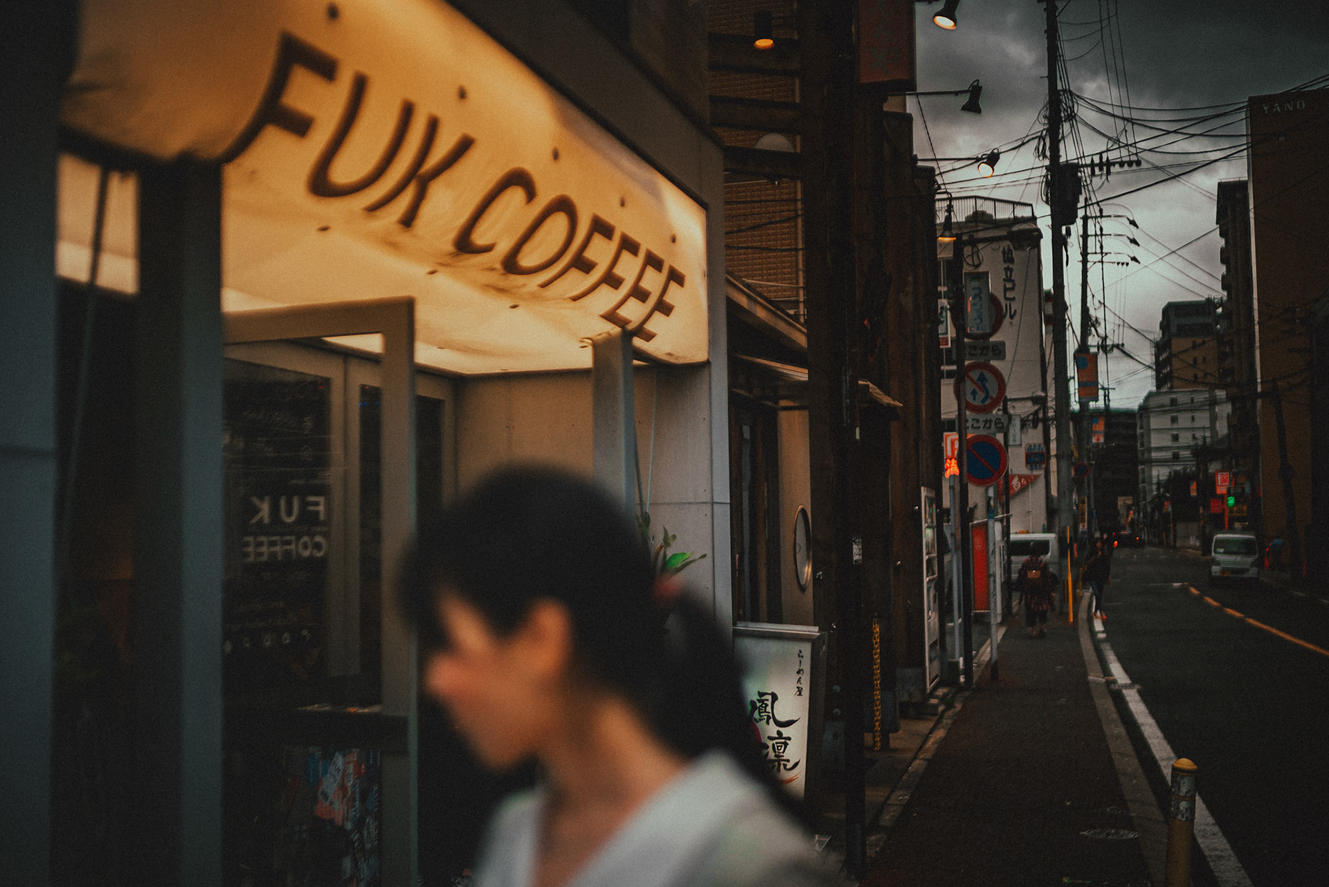 A Japanese girl out of focus in the foreground, FUK Coffee, Fukuoka, Japan, October 2018, Sony A7SII.