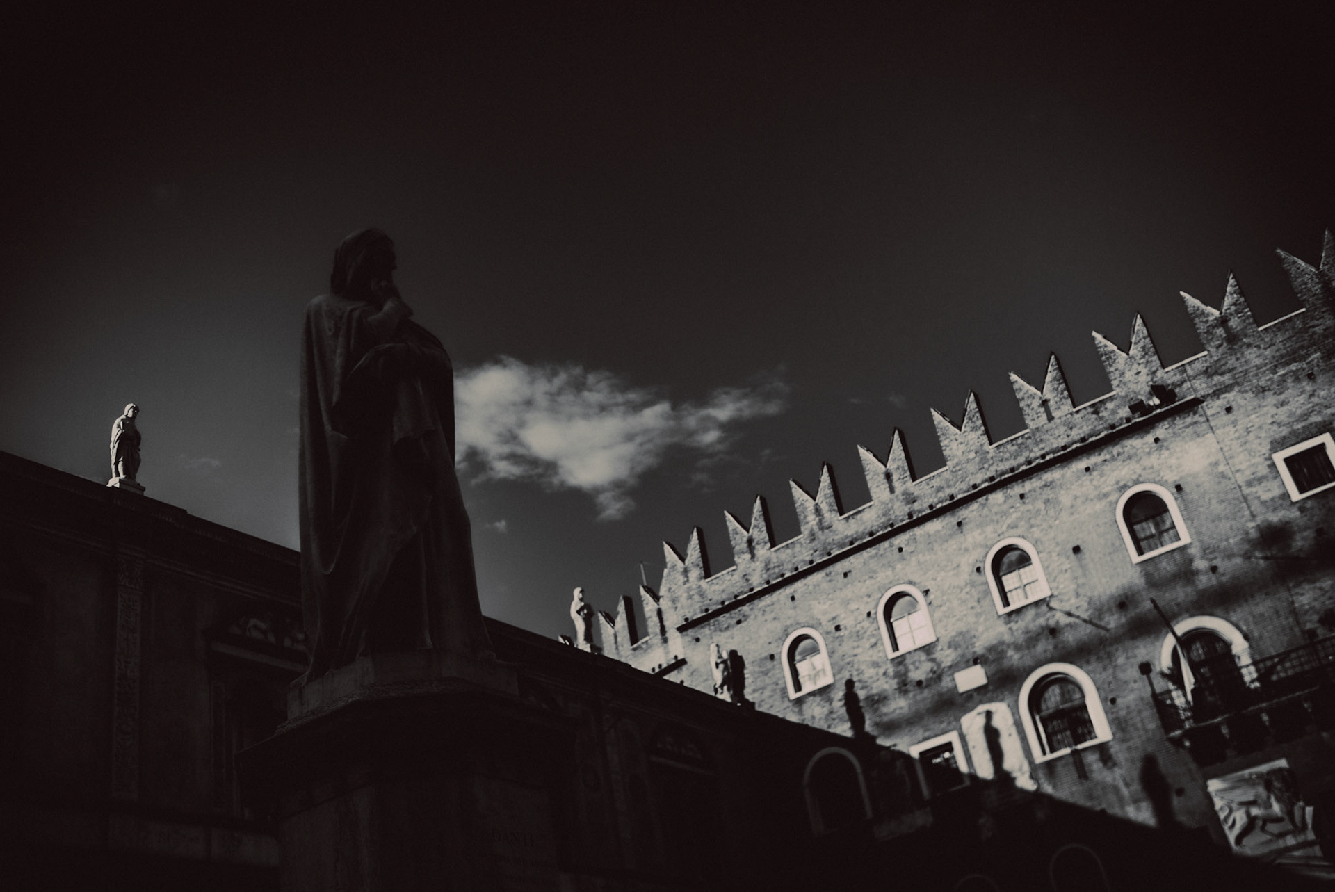 Statue of Dante Alighieri under a dark shadow, in black and white, Verona, Italy, September 2017, Leica M.