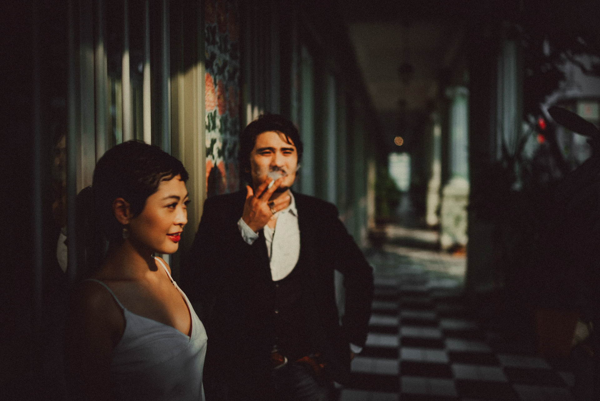 A Japanese couple sharing a lighthearted moment in a sunlit corridor with Peranakan details, from Ibuki and Emi's artsy moody engagement shoot, Pertain Road, Little India, Singapore, October 2015, Sony A7S.