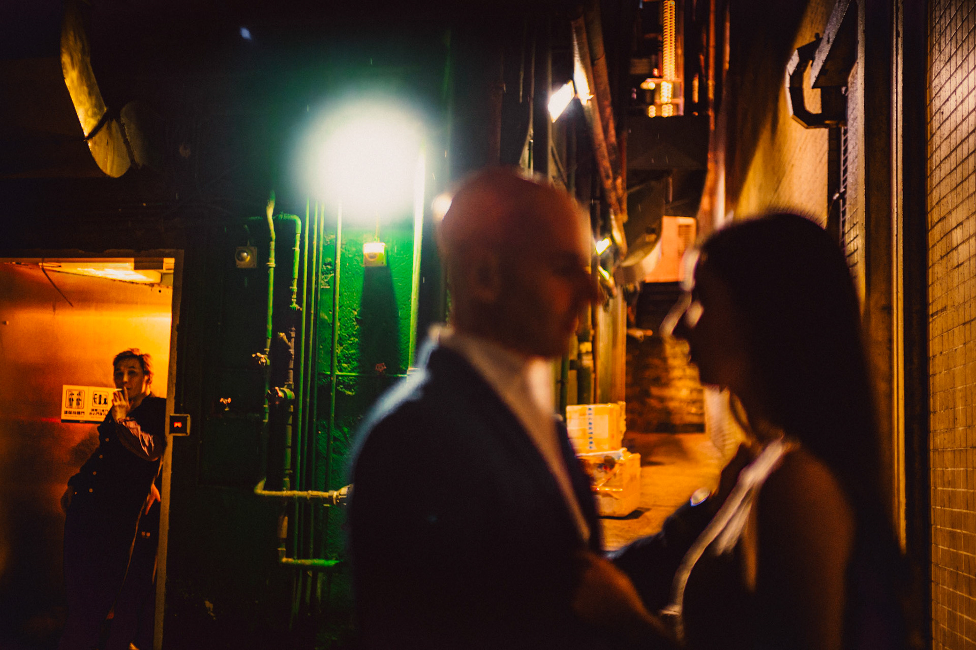 A moody and intimate late night urban engagement shoot with an incidental bystander in a prominently green alleyway in Stanley Street, from Eric and Sabrina's prewedding shoot in Central, Hong Kong, April 2019, Sony A7III.