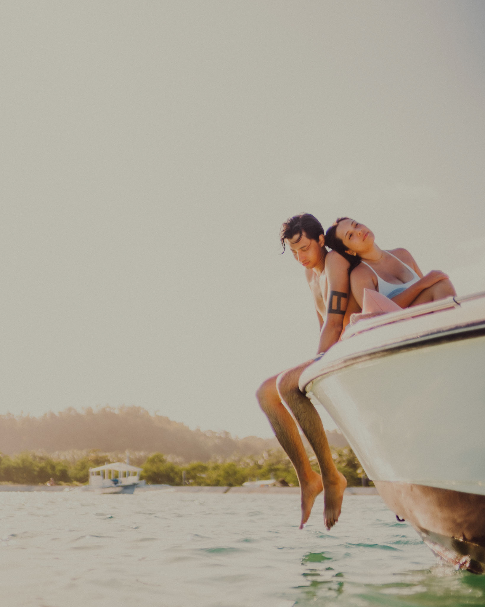 Moody adventure portraits on the edge of a speedboat, from Jeo and Bianca's island hopping honeymoon couple portrait shoot in Siargao Island, Philippines, Southeast Asia, February 2020, Sony A7III