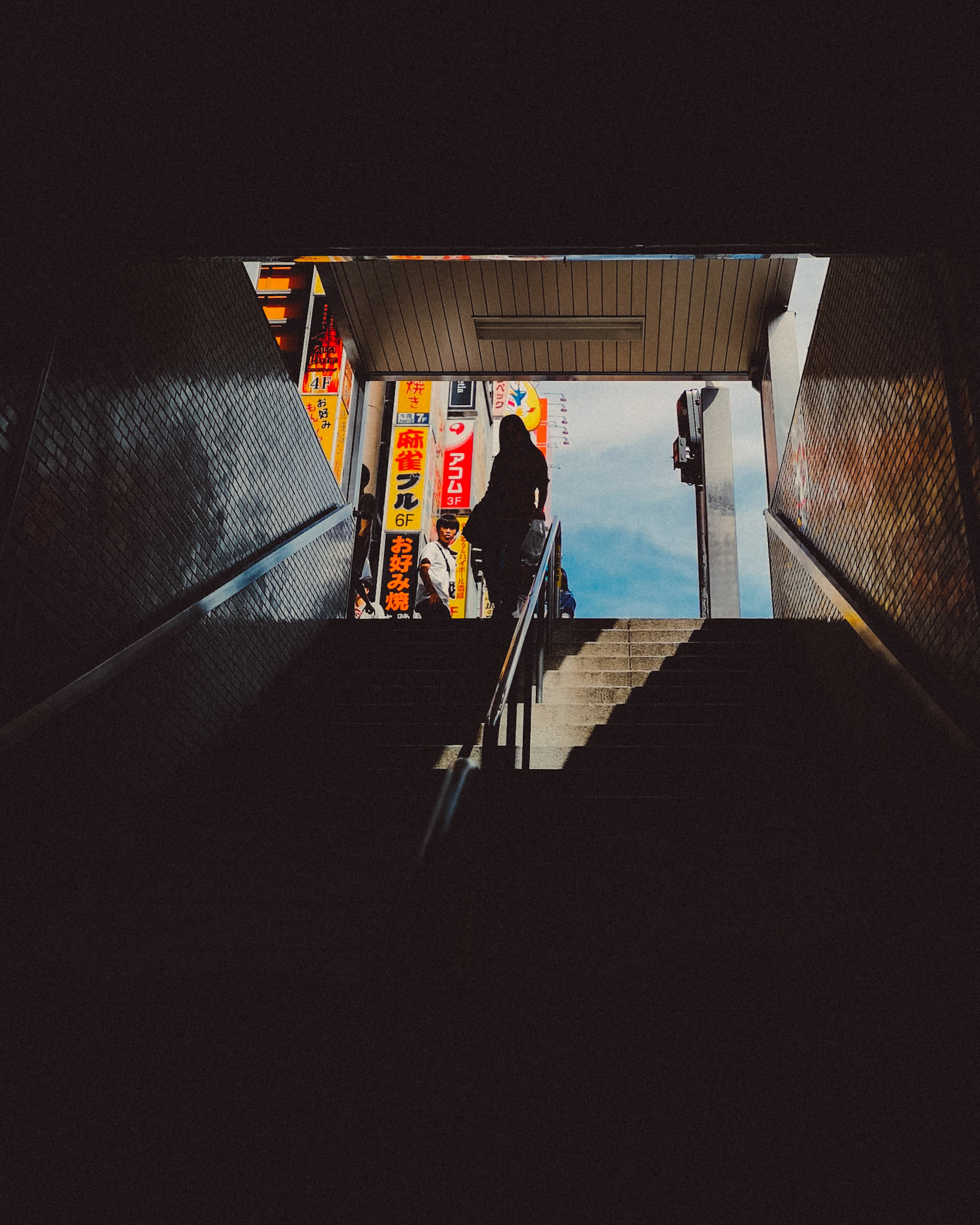 A silhouette of a woman going down a pedestrian underpass, Shinjuku, Tokyo, Japan, August 2018, Huawei P20 Pro.