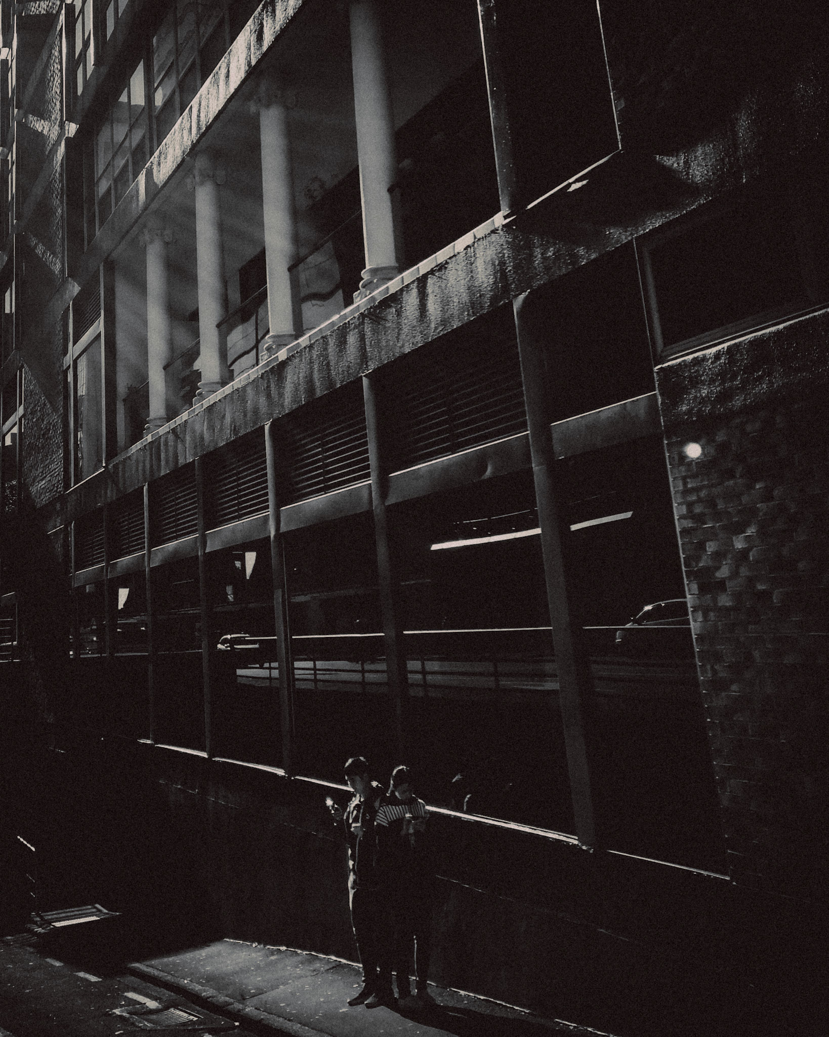 A couple standing back to back, in black and white, Auckland, New Zealand, June 2017, Huawei P10 Plus.