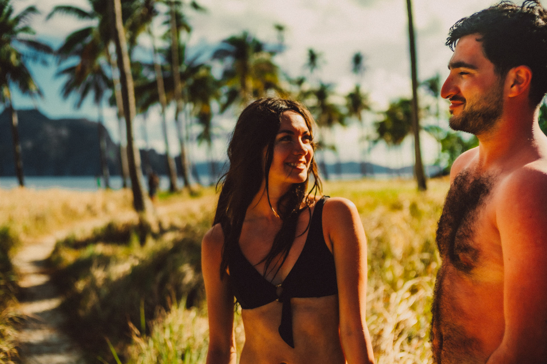 Tropical island vibe couple portraits with palm trees and cogon grass in Pinagbuyutan Island, El Nido, Palawan, Philippines, Southeast Asia, March 2020, Sony A7III.