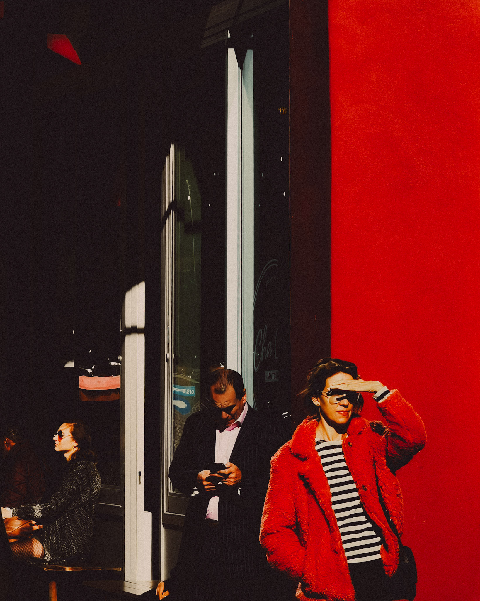 A woman wearing a red jacket in front of a bright red wall, NoMad, Manhattan, New York City, USA, November 2019, Huawei P30 Pro.