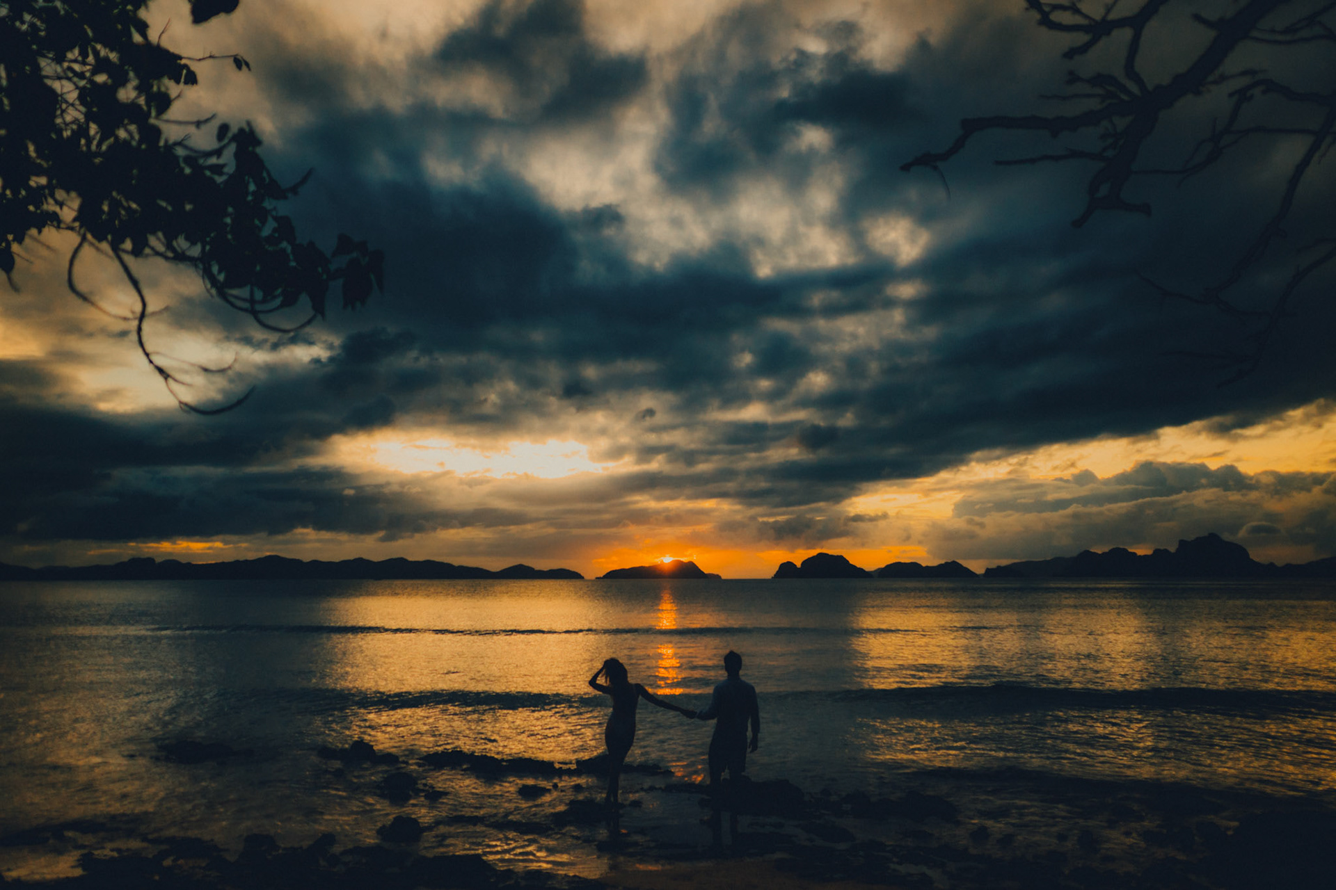 Moody sunset couple silhouettes in Las Cabanas Beach, El Nido, Palawan, Philippines, Southeast Asia, December 2019, Sony A7III.