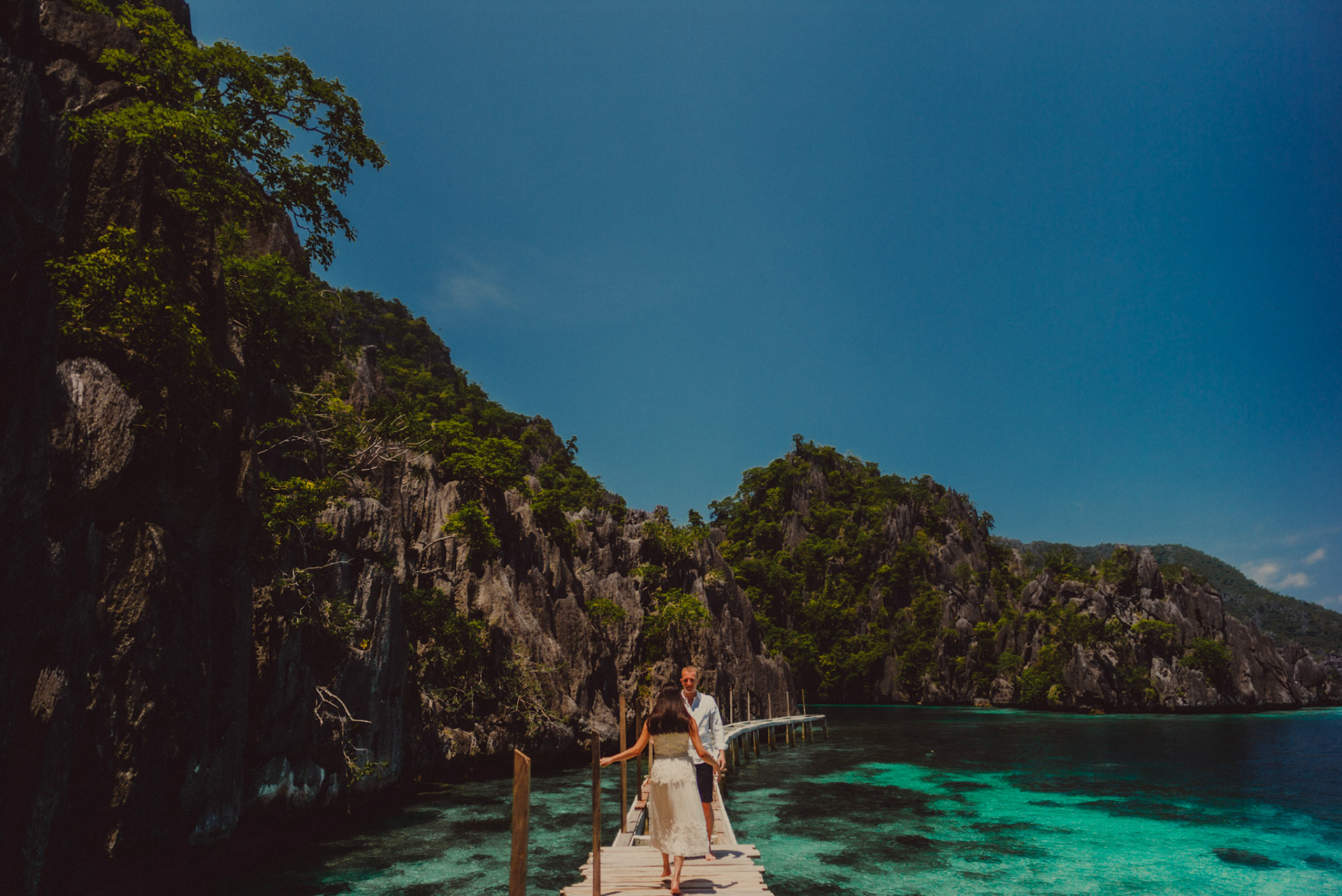 Candid couple photos at the Twin Lagoon's wooden jetty, from Renaud and Kat's island hopping adventure session in Coron, Palawan, Philippines, Southeast Asia, August 2018, Leica M