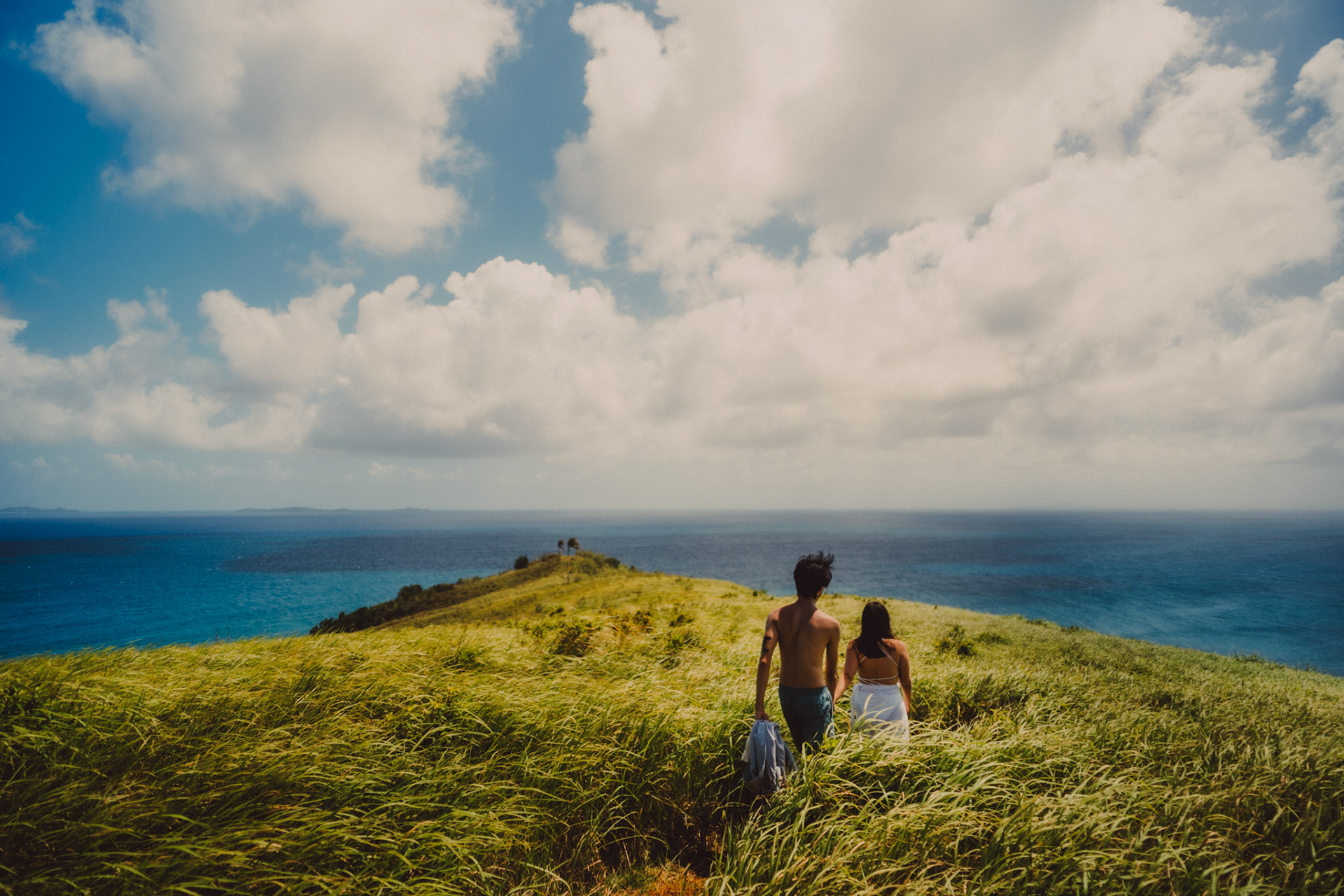 Adventure newlywed portraits with Corregidor Island's palm trees and tall cogon grass, from Jeo and Bianca's island hopping honeymoon couple portrait shoot in Surigao del Norte, Philippines, Southeast Asia, February 2020, Sony A7III