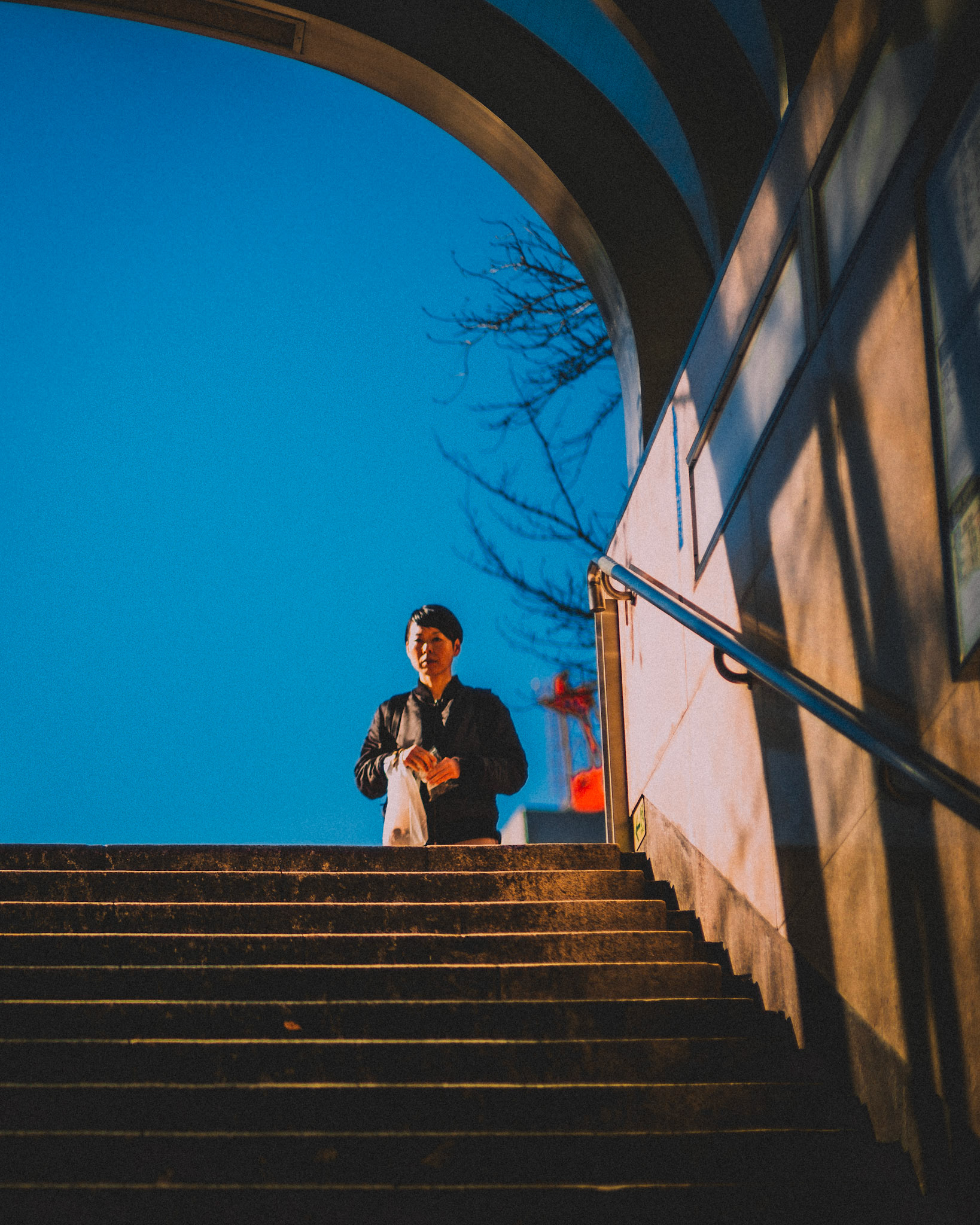 A Japanese woman walking towards a pedestrian underpass in Ginza, Tokyo, Japan, December 2016, Leica M.