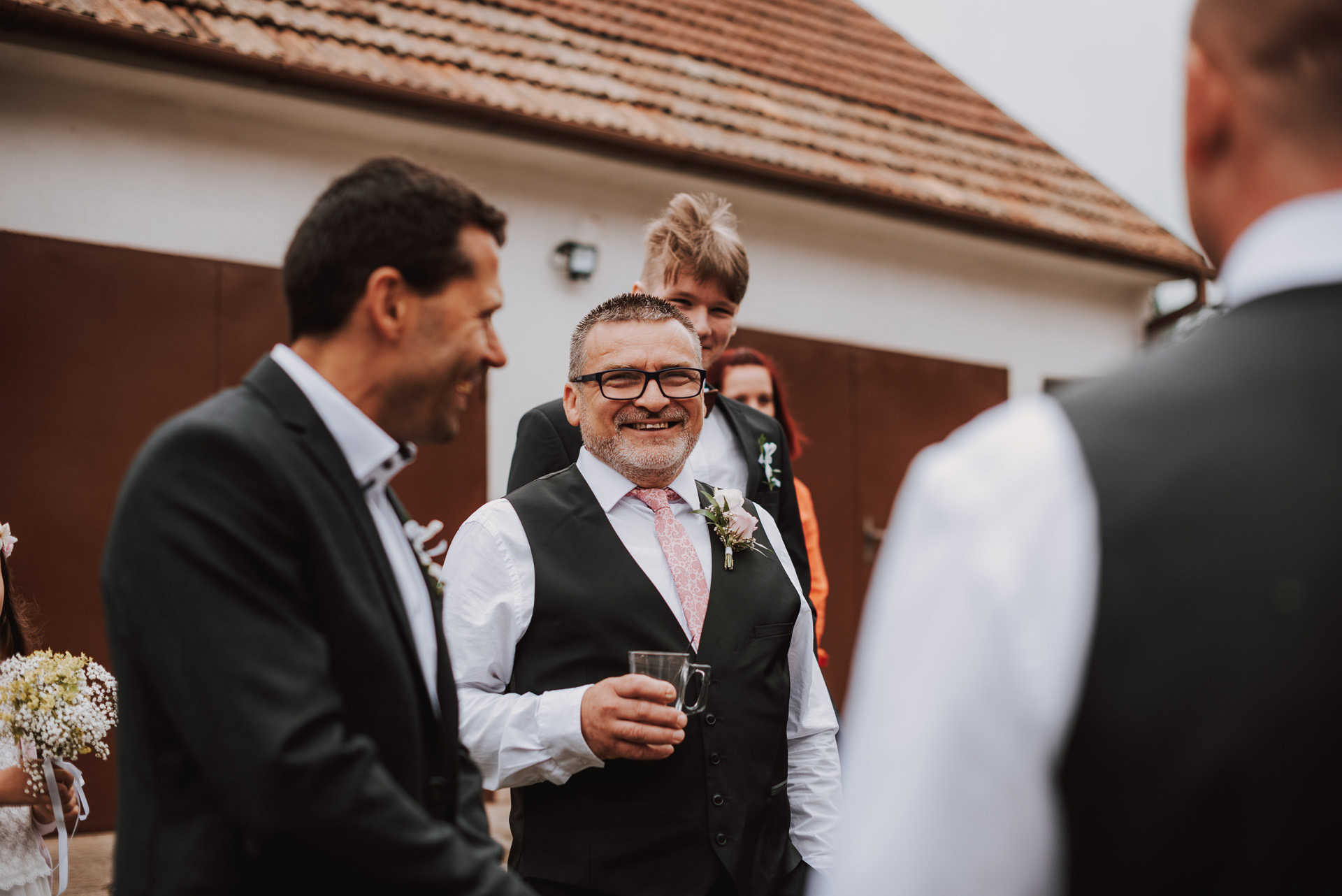 svatební hosté se pomalu scházejí na dvorku