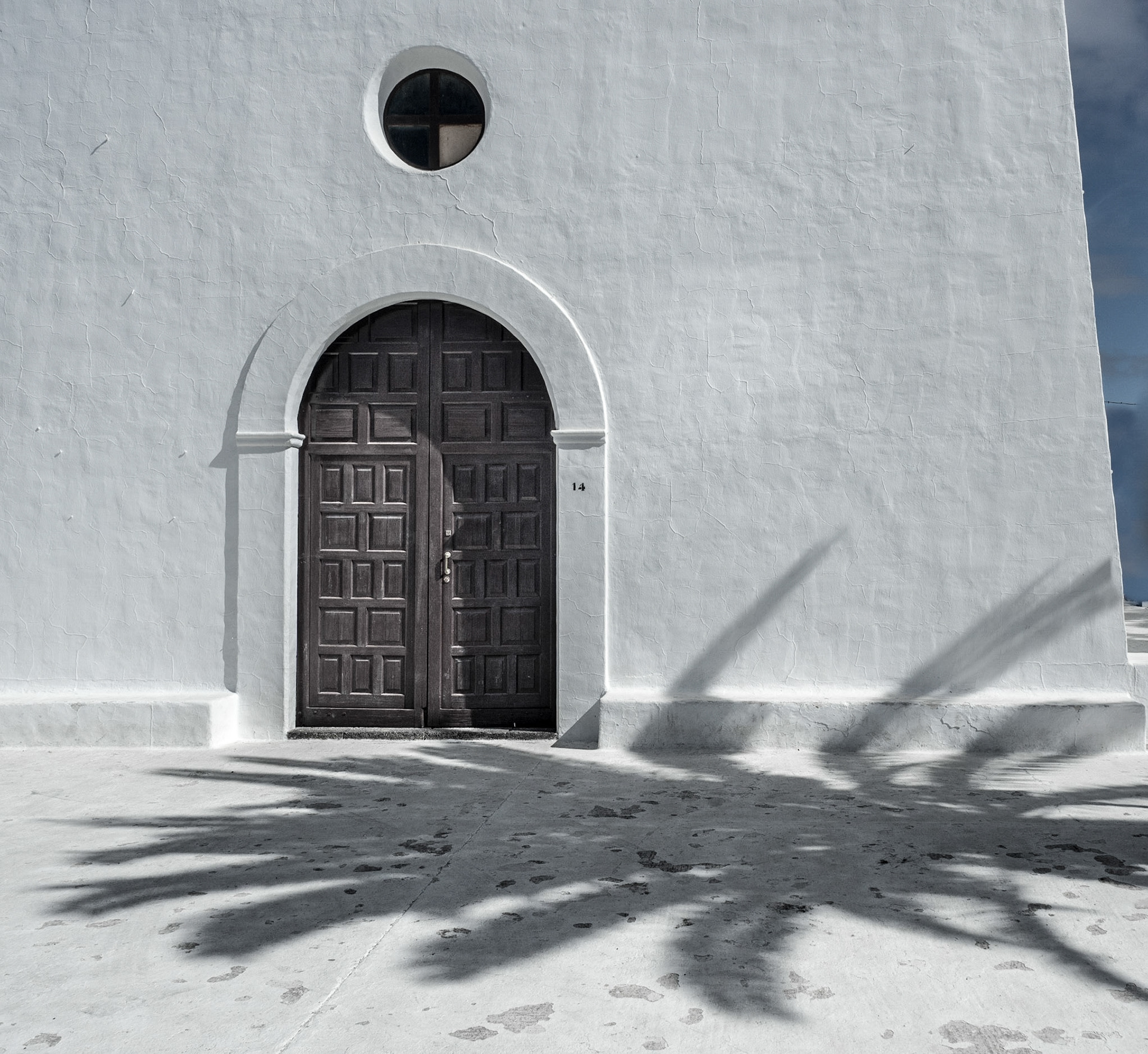 Schatten einer Palme auf der Kirche von Uga
