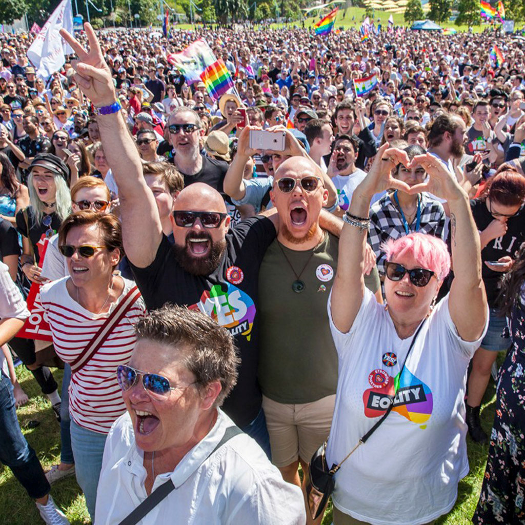 Gill Minervini, Markham Lane, Todd Hammond, and Shauna Jensen cheer together as the results are announced at the public gathering in Sydney's Prince Albert Park for the November 2017 marriage equality referendum results. Photo by Riley McFarlane for DNA Magazine.