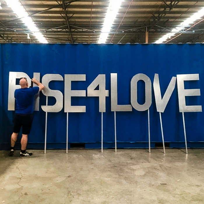 Creative producer and director Markham Lane makes final preparations for the Colours of Our Community float main message which says Rise For Love, in the Sydney Mardi Gras Community Workshop. Photo by Jane Becker.
