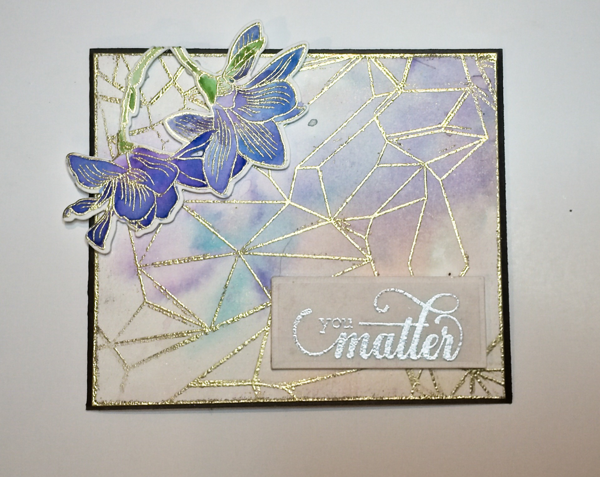 Soft Watercolor base, stamped and heat embossed background with watercolored magnolia flowers