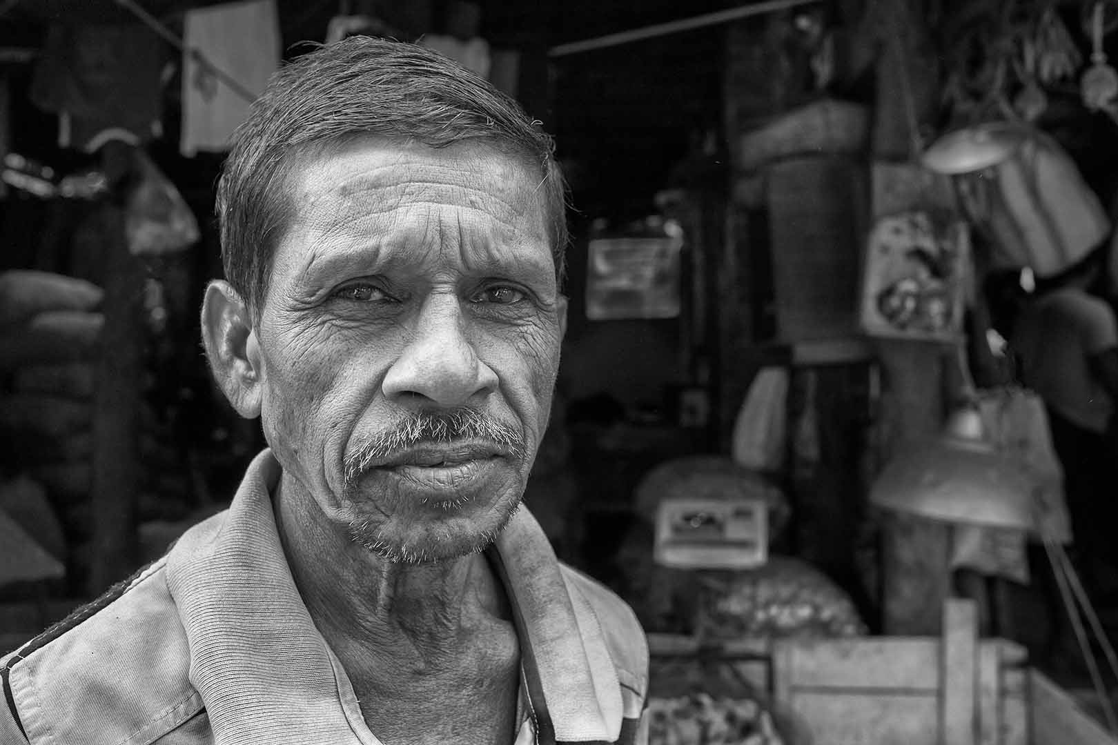 Portrait of a man in front of a market stall