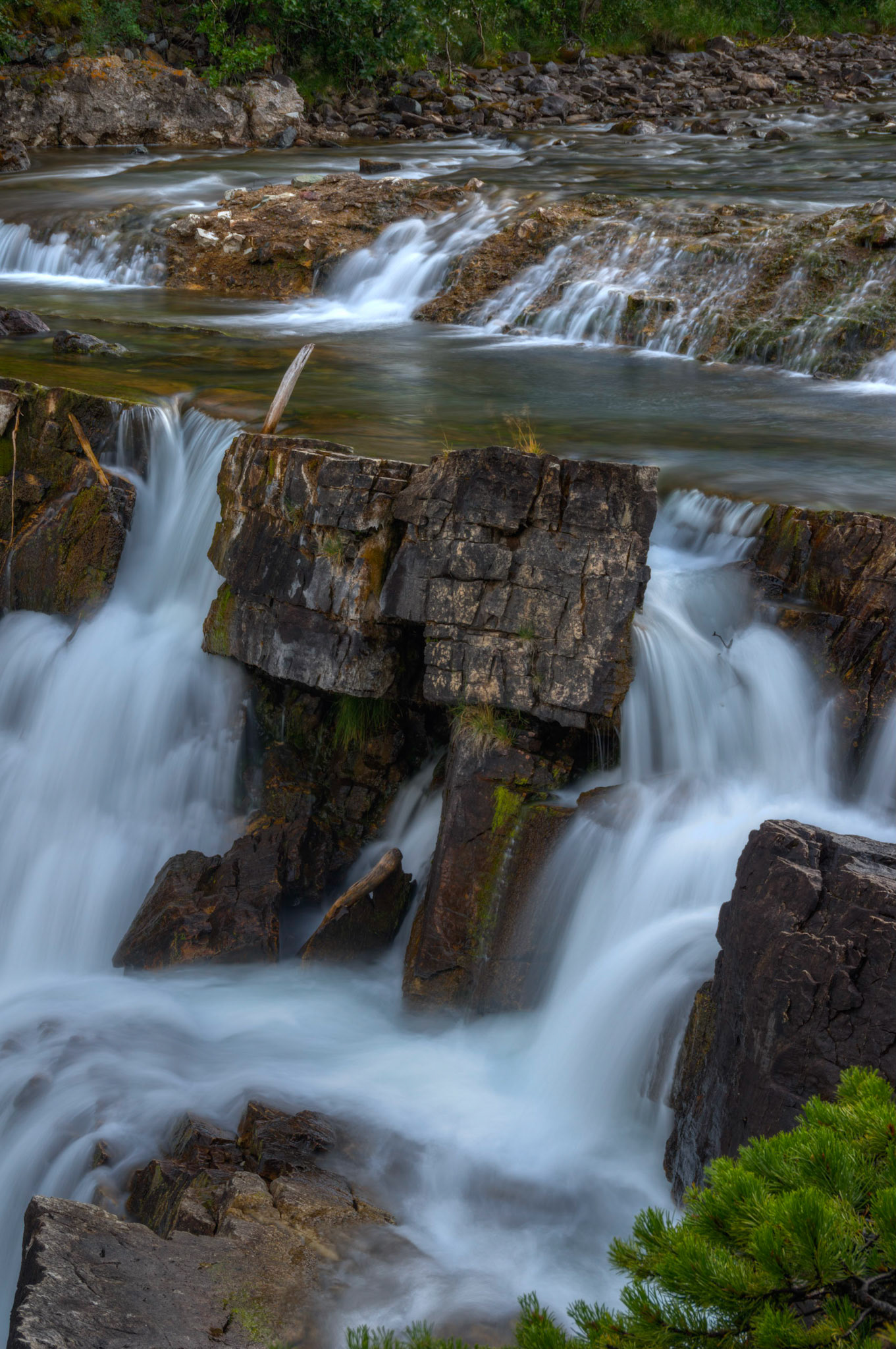 Swiftcurrent Falls, just east of Swiftcurrent Lake.Glacier National ParkJuly 27, 2015This is an HDR image consisting of 5 exposures merged in Photomatix Pro. Additional processing in Lightroom and Photoshop.PENTAX K-3, Sigma 18-250mm f/3.5-6.3 DC OS HSMISO 100 53 mm  1.6 sec at ƒ / 11