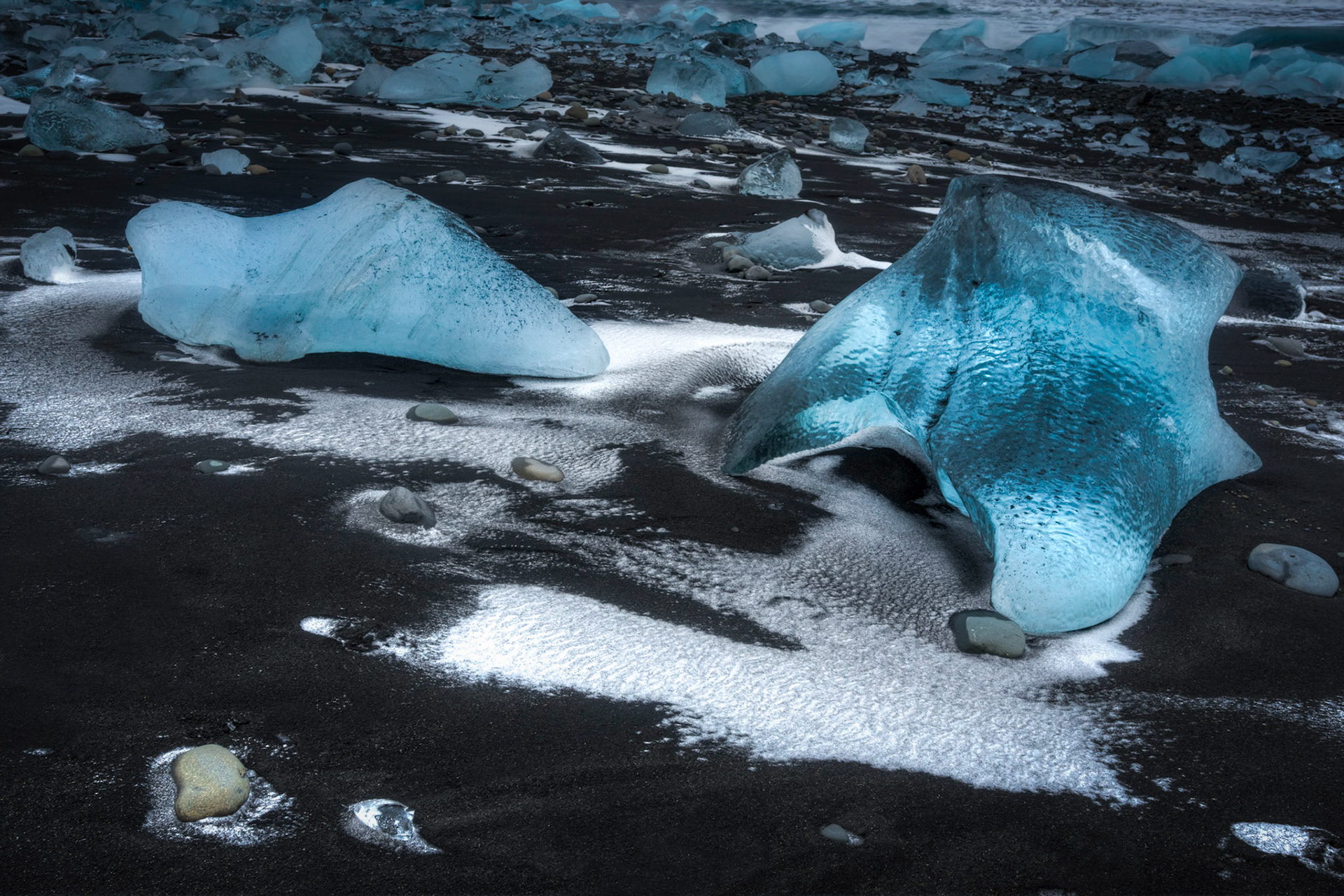 Ice boulders surrounded by windblown sand and snow on the beach near Jökulsárlón, after sunset.Austurland, IcelandFebruary 1, 2016This is an HDR image consisting of 5 exposures merged in Photomatix Pro. Additional processing in Lightroom and Photoshop.PENTAX K-3, SIGMA 18-35mm F1.8 DC HSM A013ISO 200 23 mm  0.8 sec at ƒ / 7.1