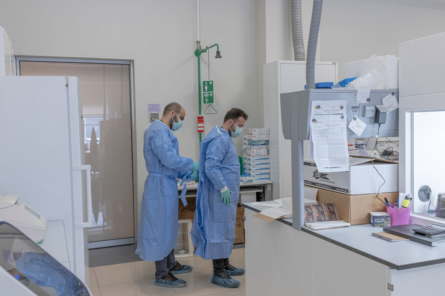 Molecular biologists as they help each other to wear protective equipment for laboratory in at a private laboratory of hospital in Istanbul on 1 May 2020.