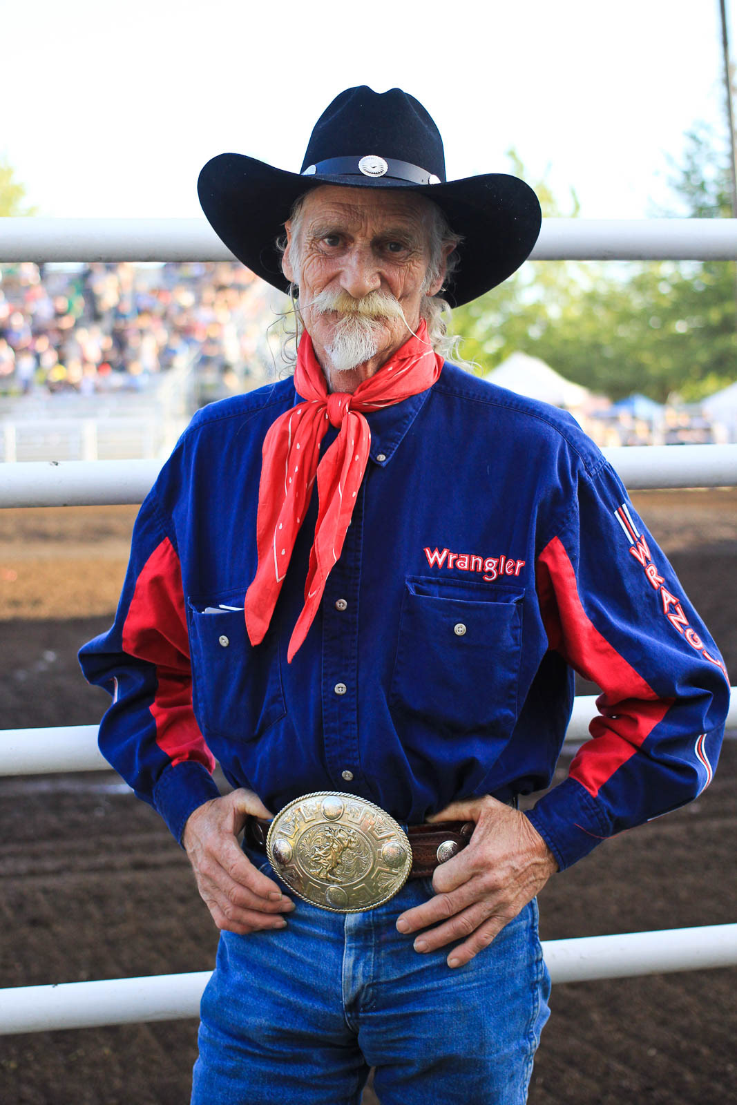 Old cowboy proudly wears his championship rodeo belt buckle