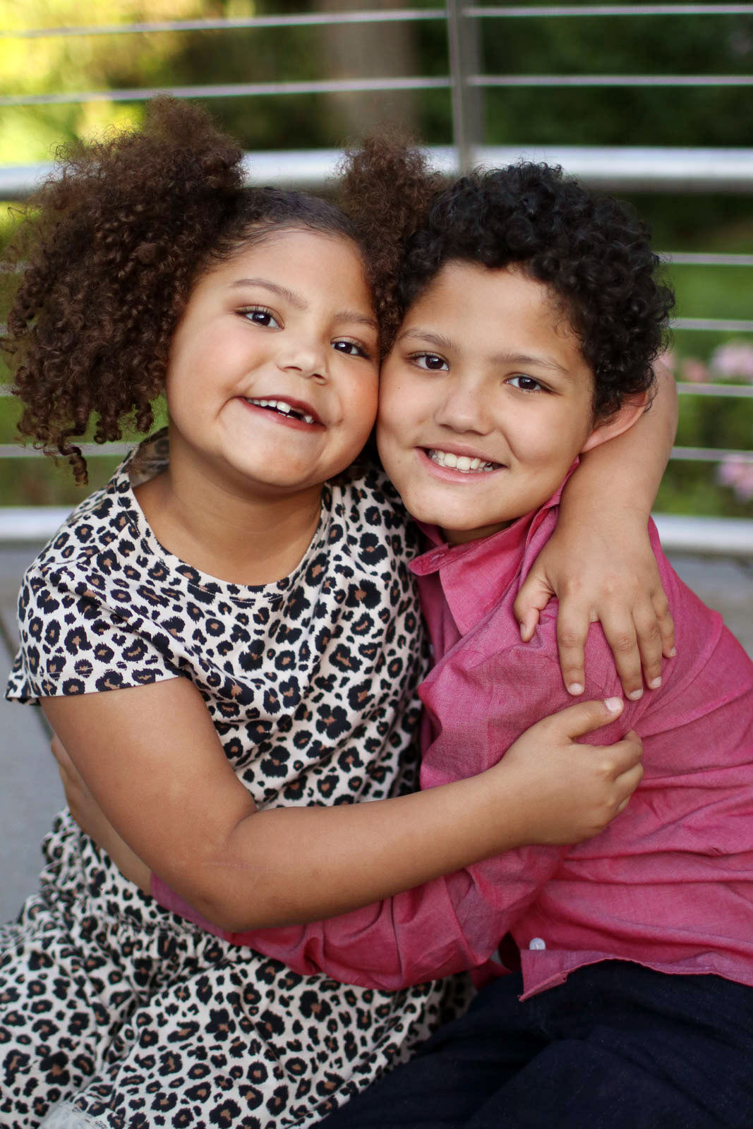 Portrait of brother and sister, smiling with arms around each other