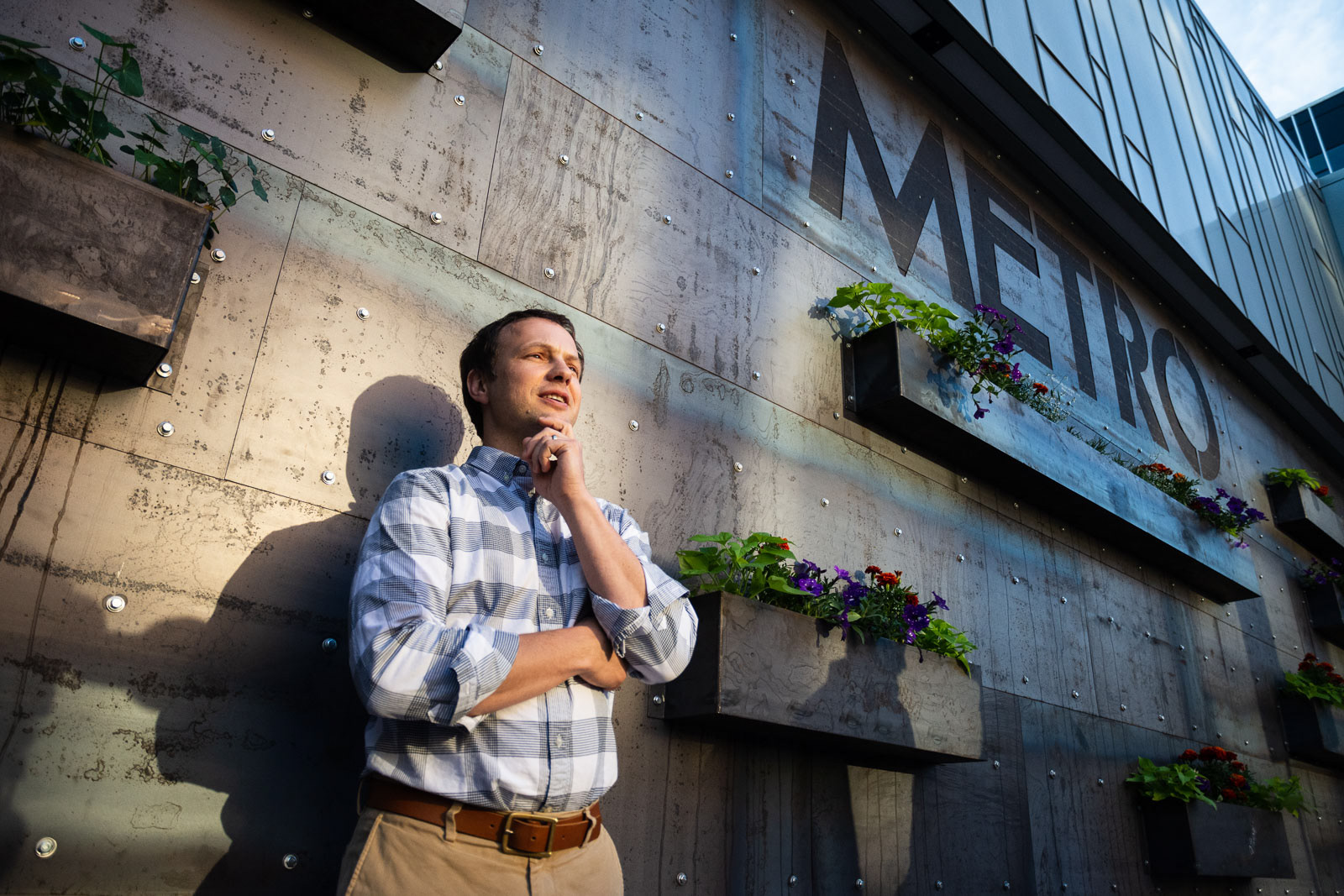 Low angle view of a man against a wall looking up into the sunlight