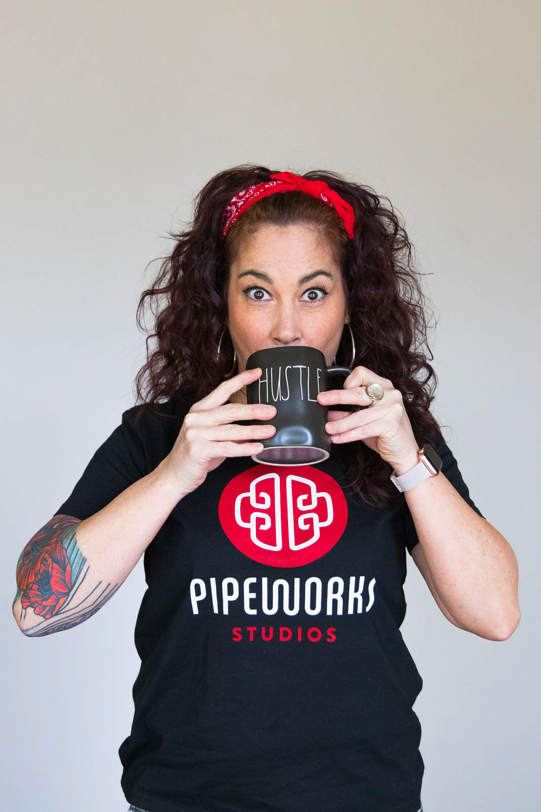 Woman in Pipeworks Studios t-shirt posing with coffee mug