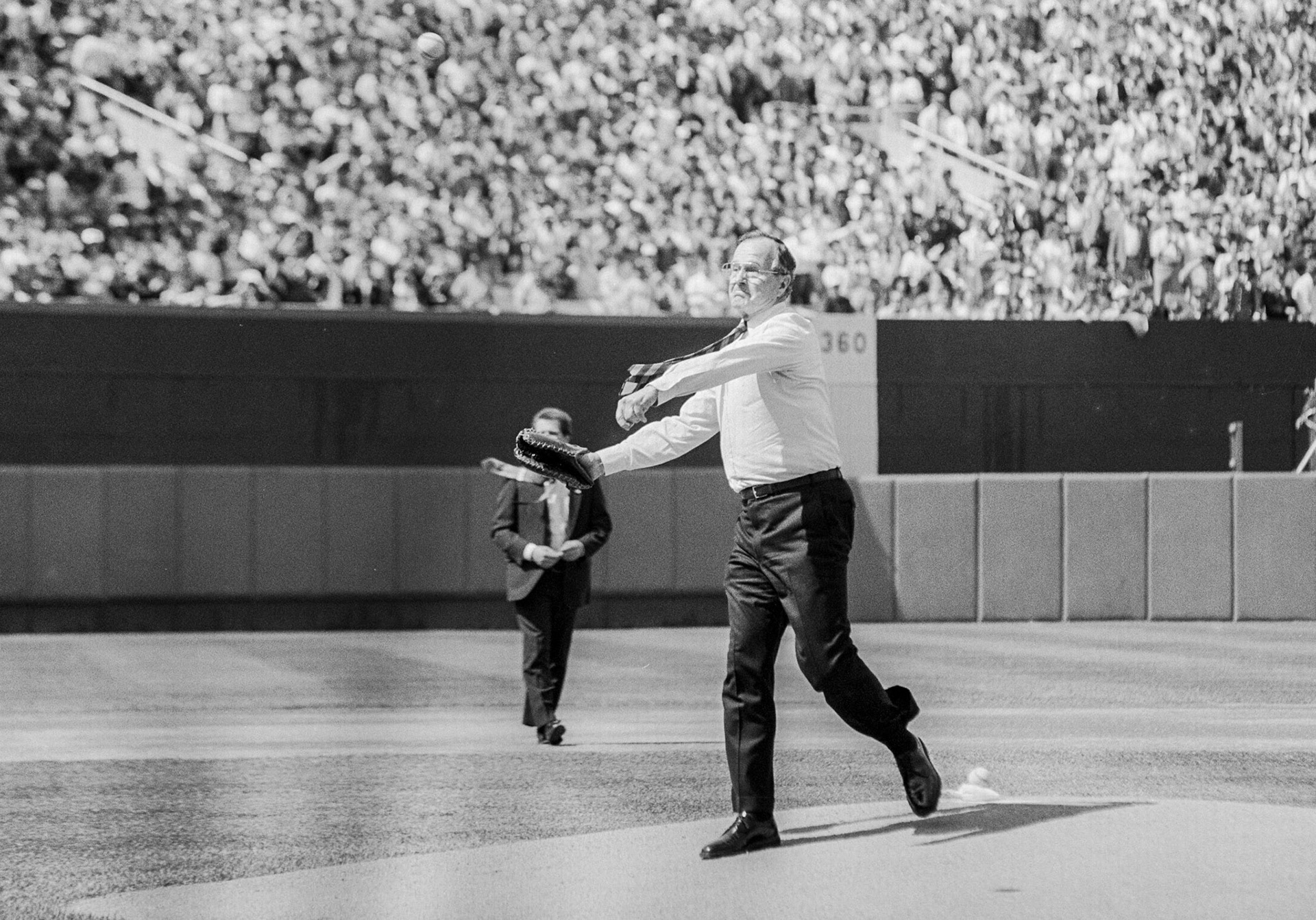 President George H.W. Bush throws out the ceremonial first pitch at Baltimore Stadium for the Orioles Opening Day. President Bush wore his old Yale mitt as he threw out the first ball, April 3, 1989.
