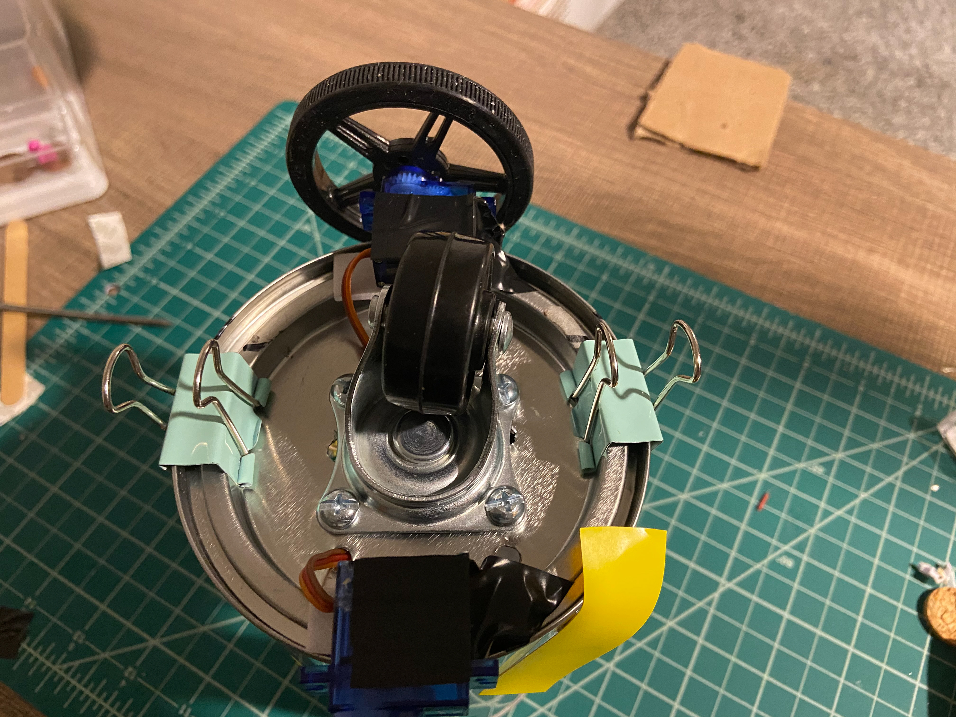 So I decided to center it and retape the servo and side wheels on the lid. It was still off balance. So I decided to add some binder clips.