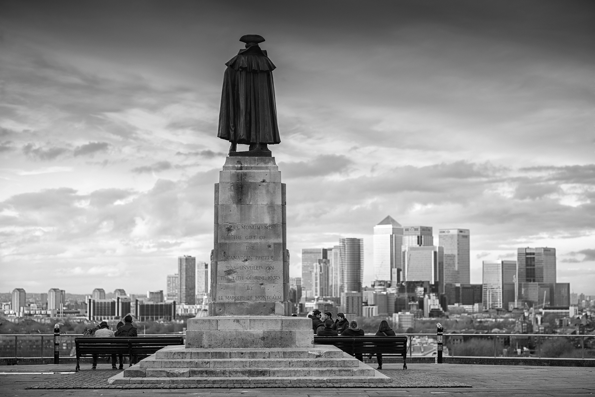 Schwarzweißes Bild, Statue auf einem hohen Sockel blickt auf die Docklands, London, Greenwich, fotobagaluten