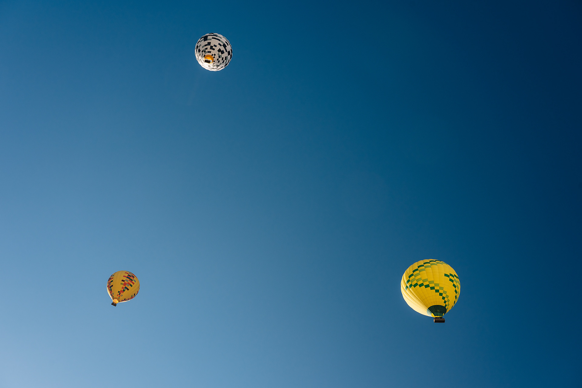 Tres globos aerostáticos en el cielo ustrando un artículo sobre el punto en composición fotográfica.