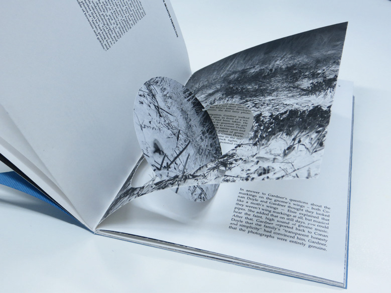 Photo of the small book , lay open, showing circular cut-out spinning