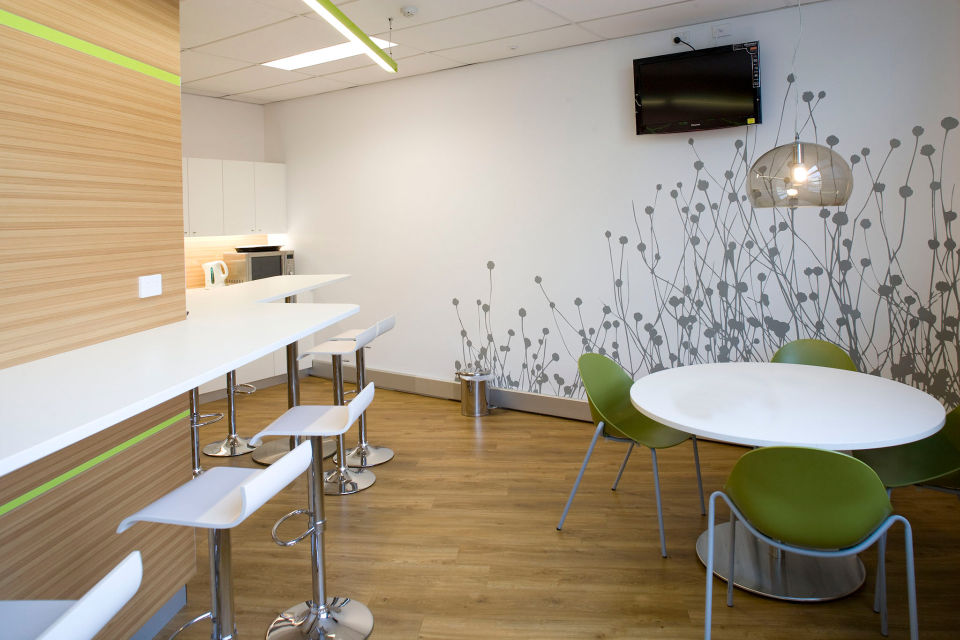 Breakout space with botanical wall mural, timber panelling and soft lighting