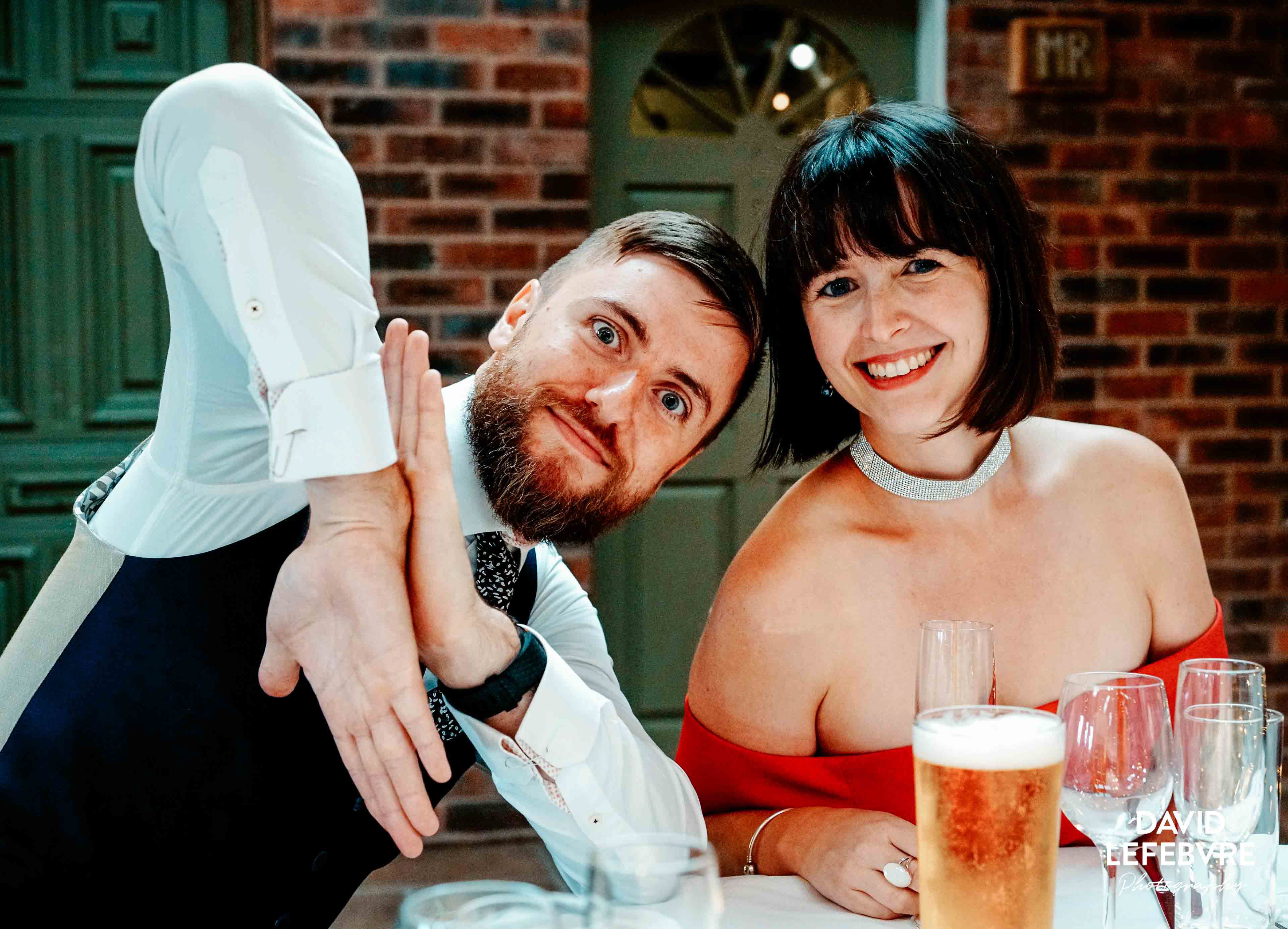 fun pair at wedding table smiling at owen barn house wedding venue