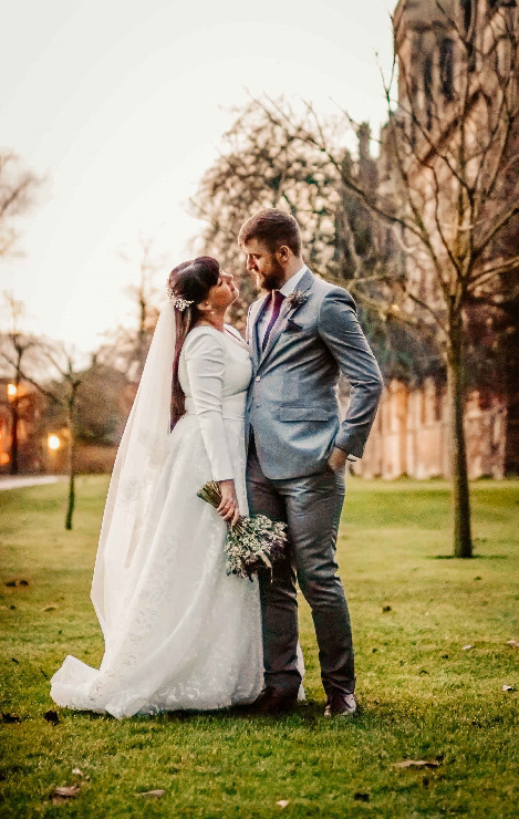 intimate groom and bride photo stood on grass after covid december wedding with david lefebvre an oxfordshire wedding photographer