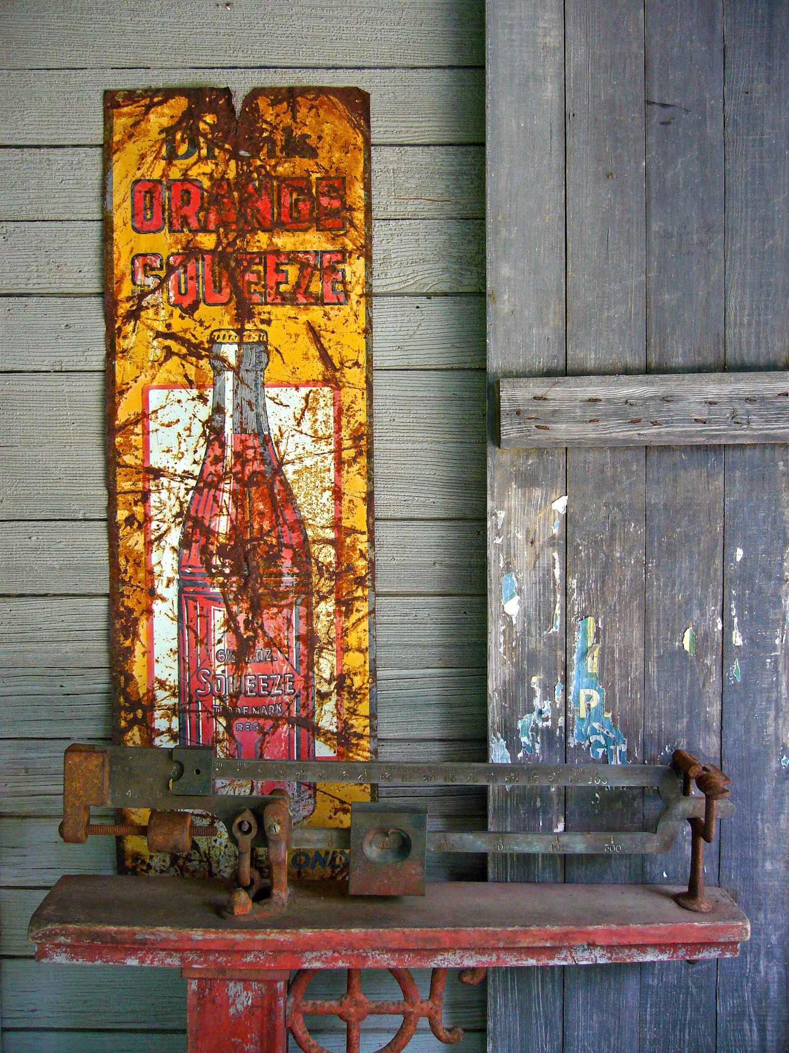 An old sign advertises Orange Squeeze in Bastrop Texas.