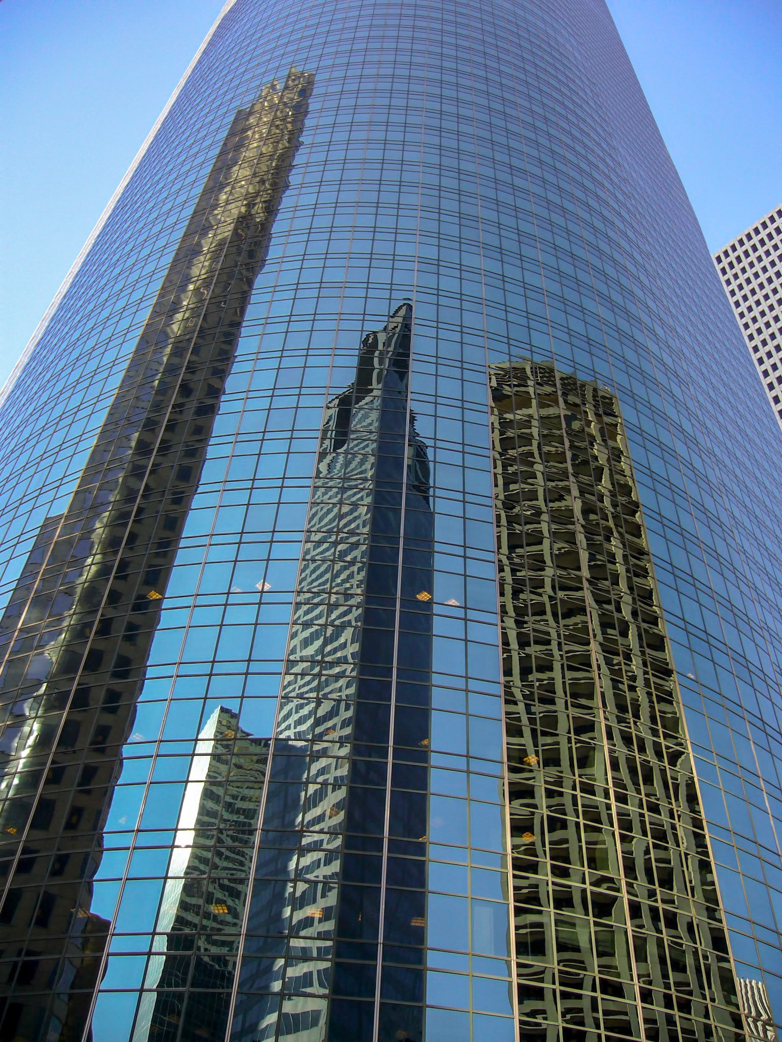 Shiny buildings in downtown Houston Texas reflect the other high-rises.