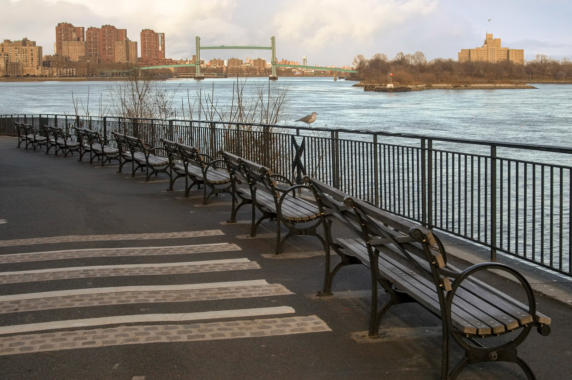 Benches line the walkway along the East River in the upper east side in Manhattan New York.