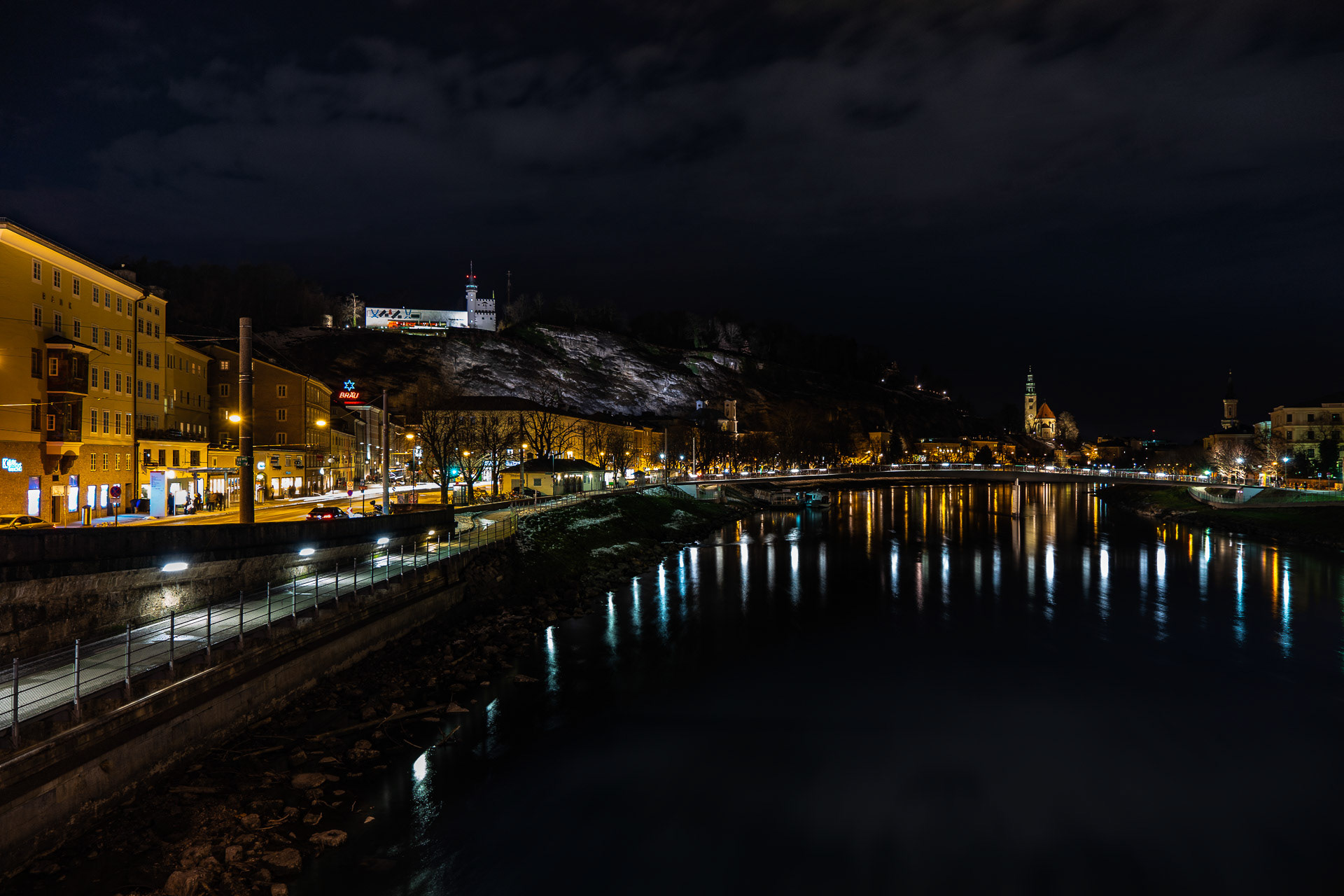 View of the nocturnal Salzach from the bridge Staatsbrücke to the west. At the top left you can see the Museum of Modern Art