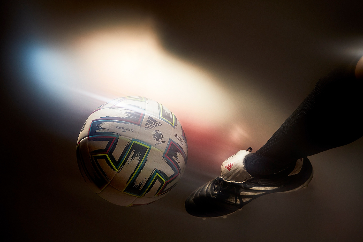 Football boot kicking ball action shot