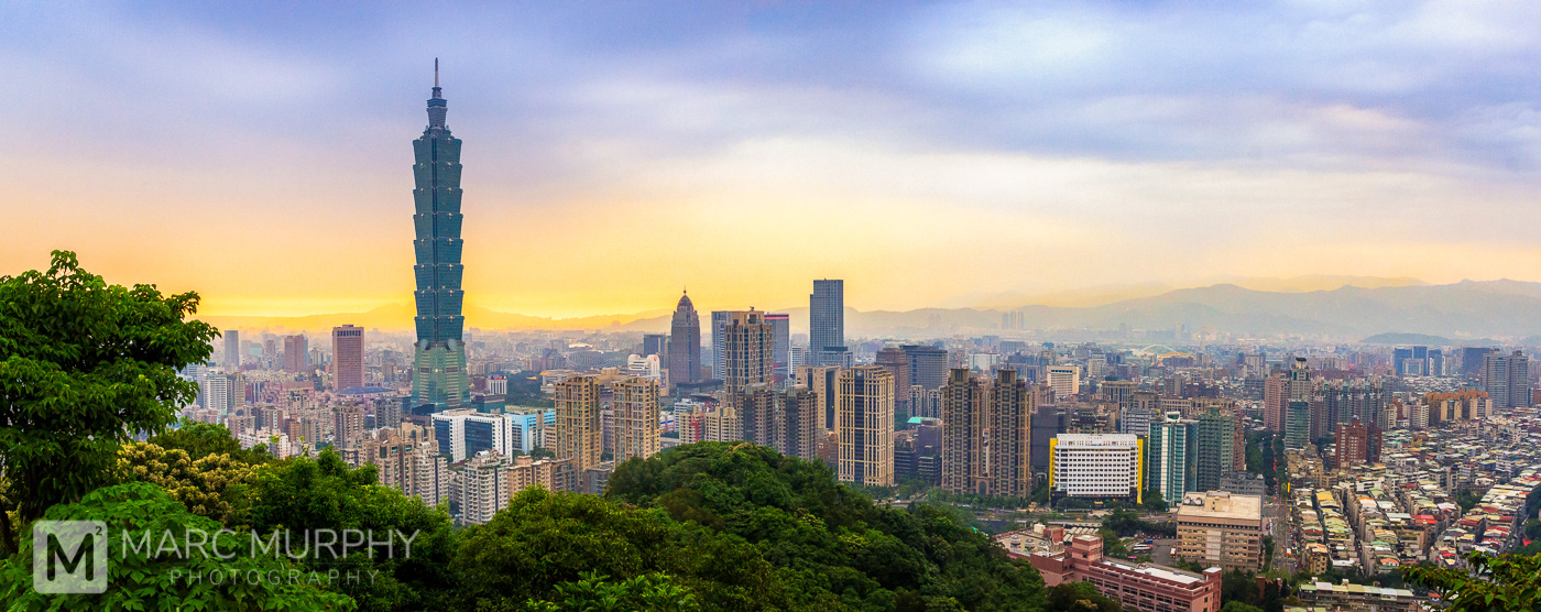 Downtown Taipei Taiwan Skyline in Spring at Sunset with Blue, Yellow and Orange Sky, Taipei 101, Other Tall Buildings and Mountains