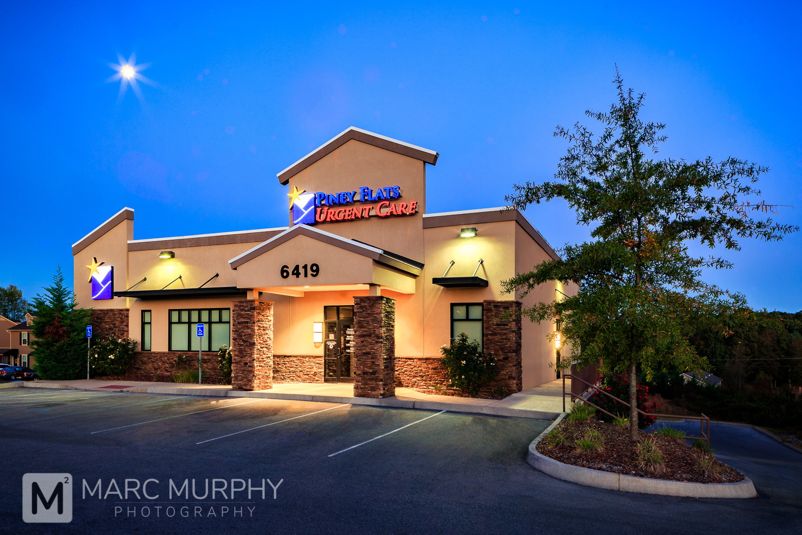 EFIS and Stacked Stone Urgent Care Medical Office Building Exterior Early Morning Before Sunrise with Moon in Clear Sky