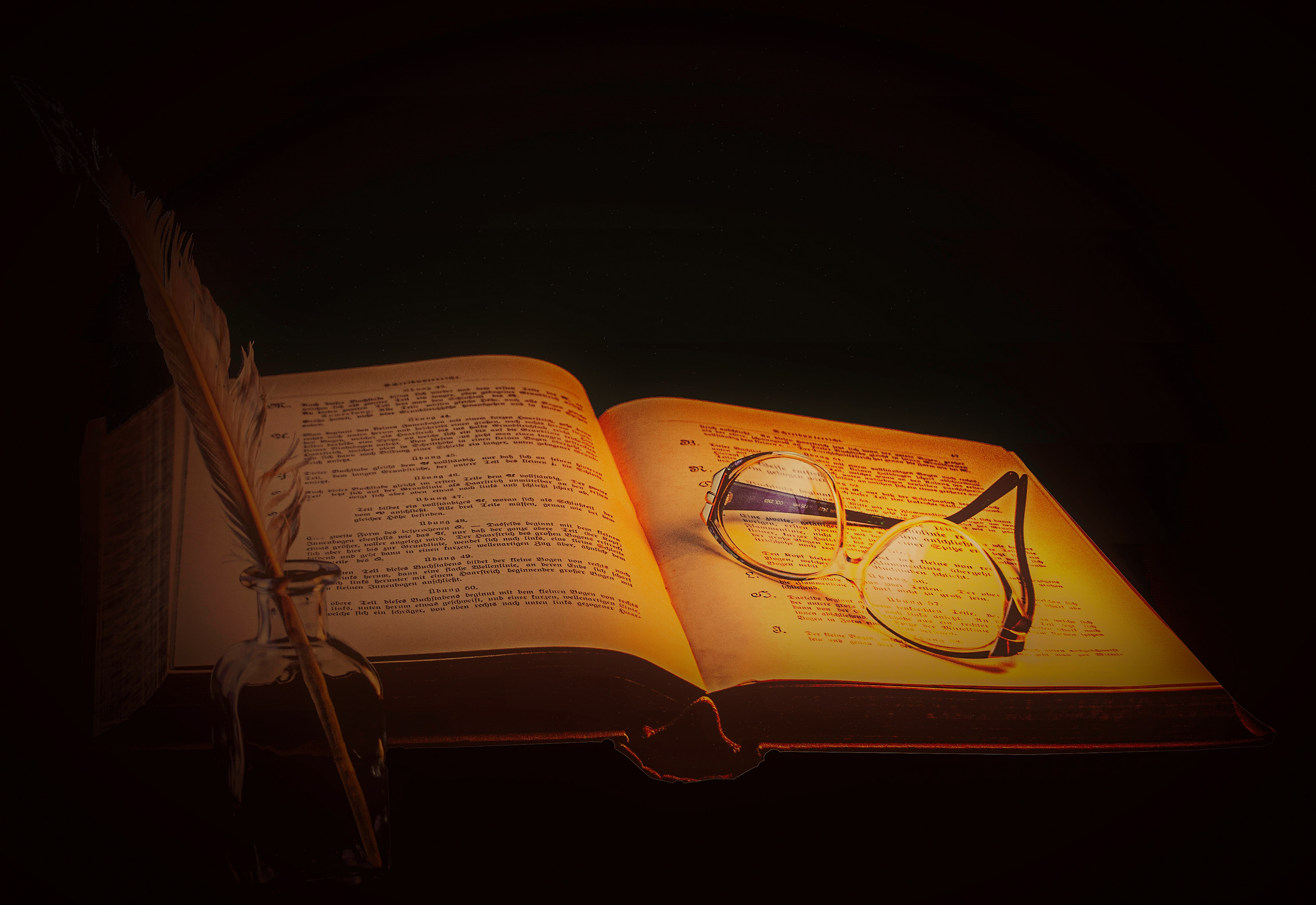 Ein aufgeschlagenes Buch, darauf eine Brille, links eine Schreibfeder im Glas