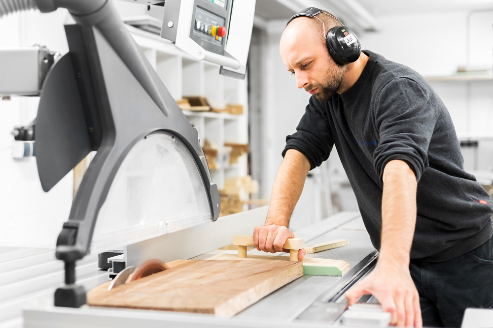 Thema: Fotografie für Unternehmen in Muenchen - Aufnahme eines Schreiners bei der Arbeit an einer Kreissäge - Fotograf: Jacob Kanzleiter
