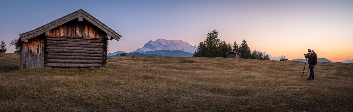 der Fotograf und die Hütte in den Bergen.