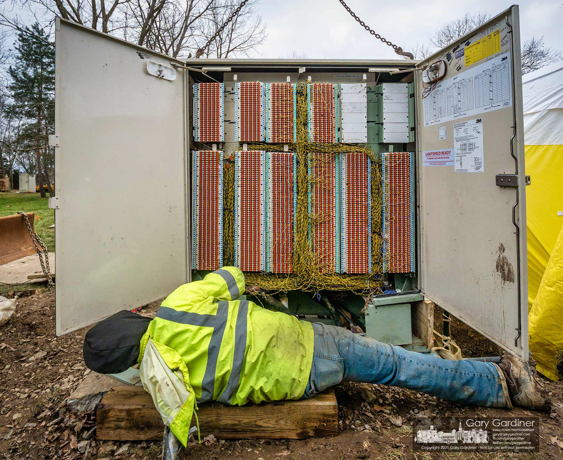 A technician adjusts the placement of a section of the ATT copper cable connection box on Huber Village Blvd. during repairs for the structure damaged by a car crash. My Final Photo for Jan. 7, 2021.