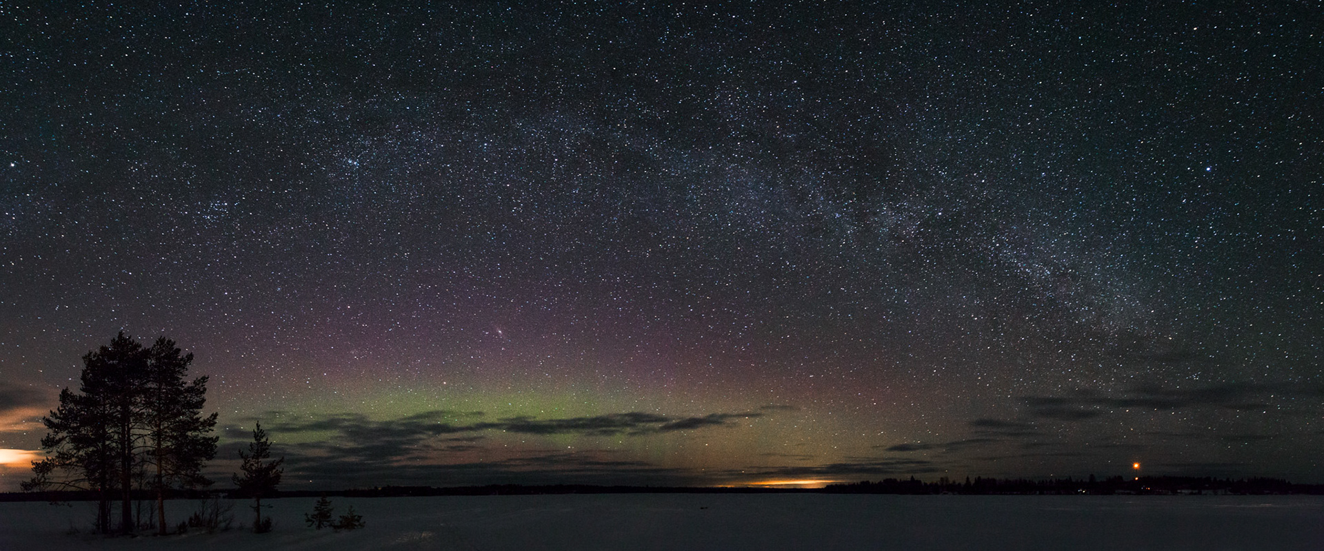 Milky way and aurora over frozen lake, Saija, Finland