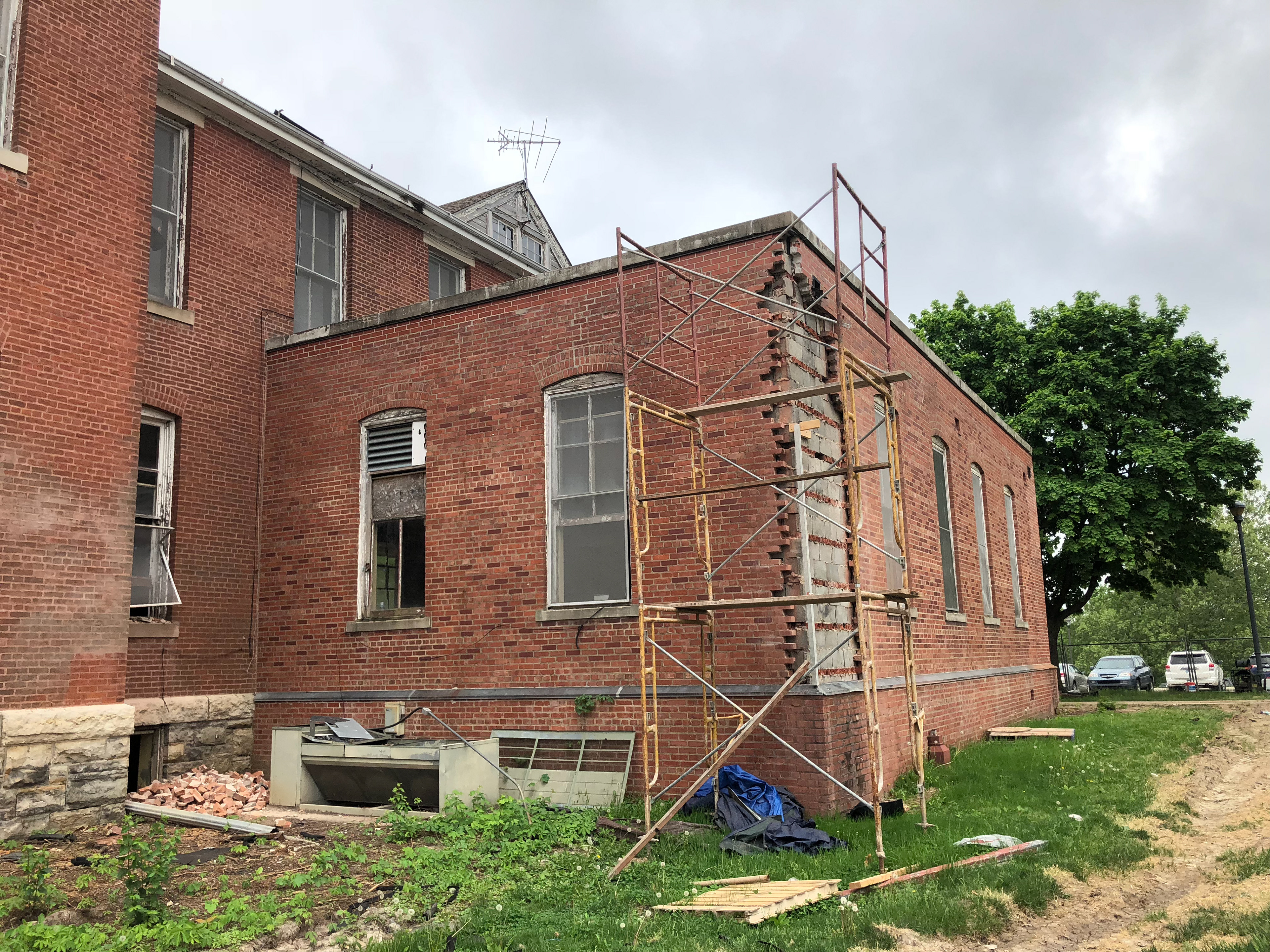 Masonry restoration underway at rear addition downspout locations.