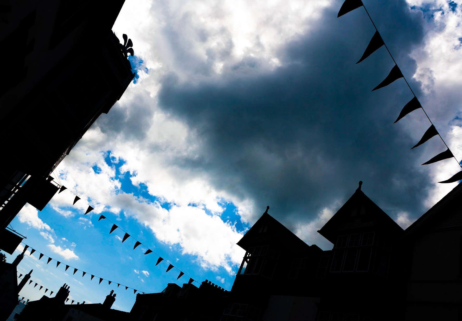 Regenwolken über der festlich geschmückten BRIDGE STREET in der britischen Küstenstadt LYME REGIS.