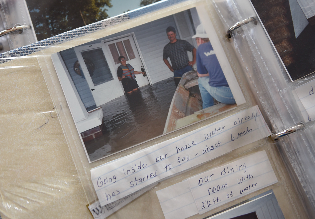 A photo of Steve and Janet Wehrle in their flooded home during the 1993 flood sits in an album Sunday, December 8, 2019 in Rhineland, Missouri. The caption was written by Janet and reads “Going inside our house, water already has started to fall - about 6 inches.”